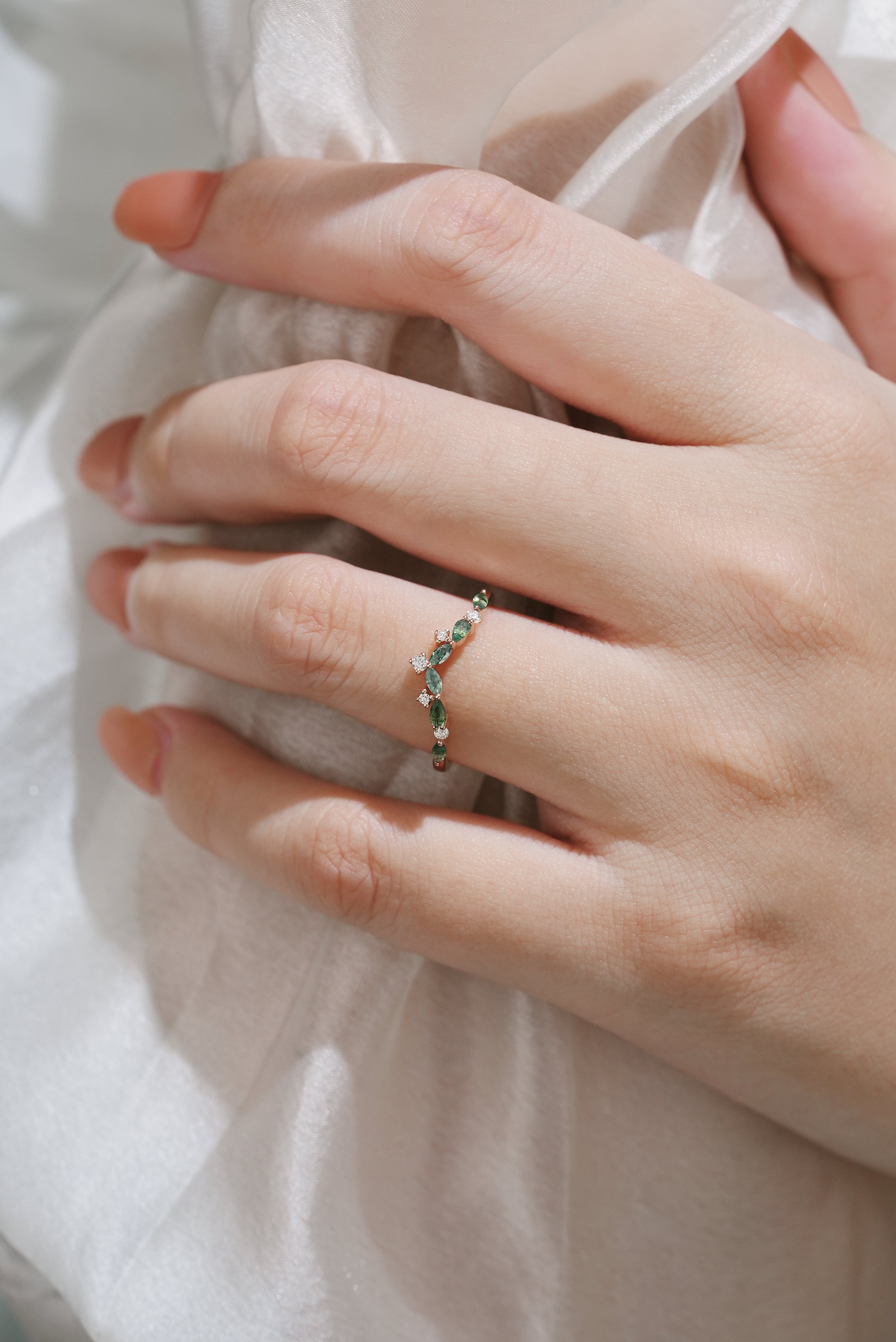 Hand wearing curved moss agate wedding band