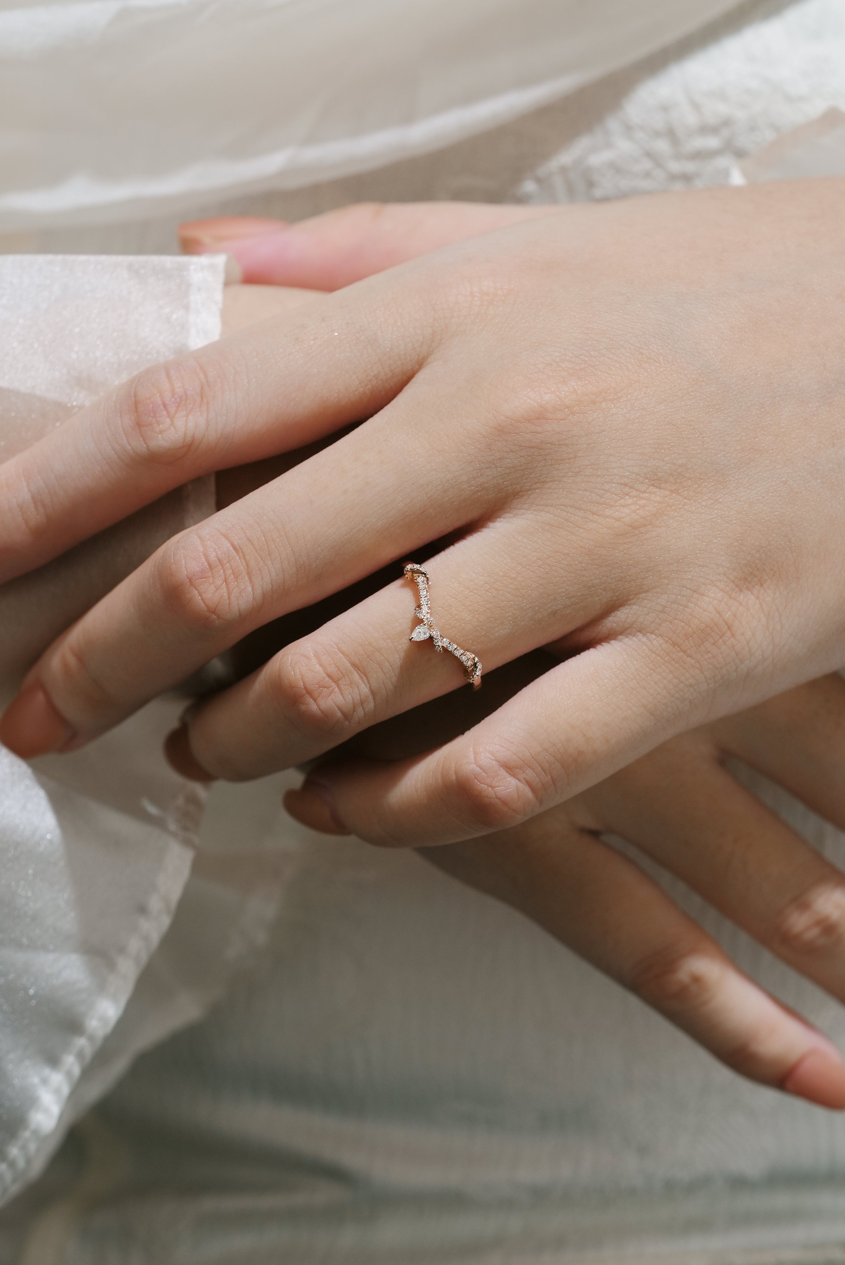 Rose gold moissanite twisted stacking wedding band on a hand, bridal ring set