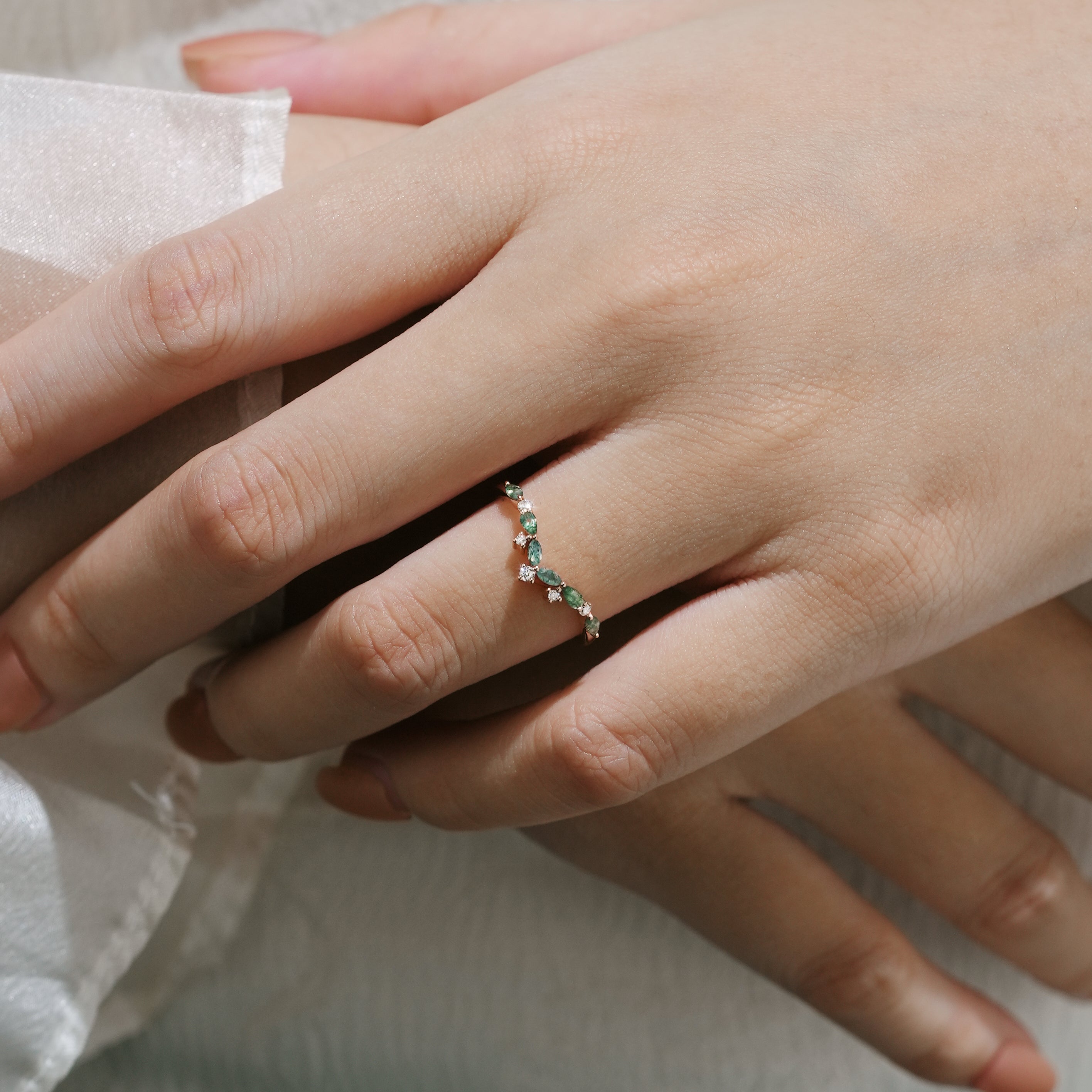 Hand wearing moss agate curved wedding band