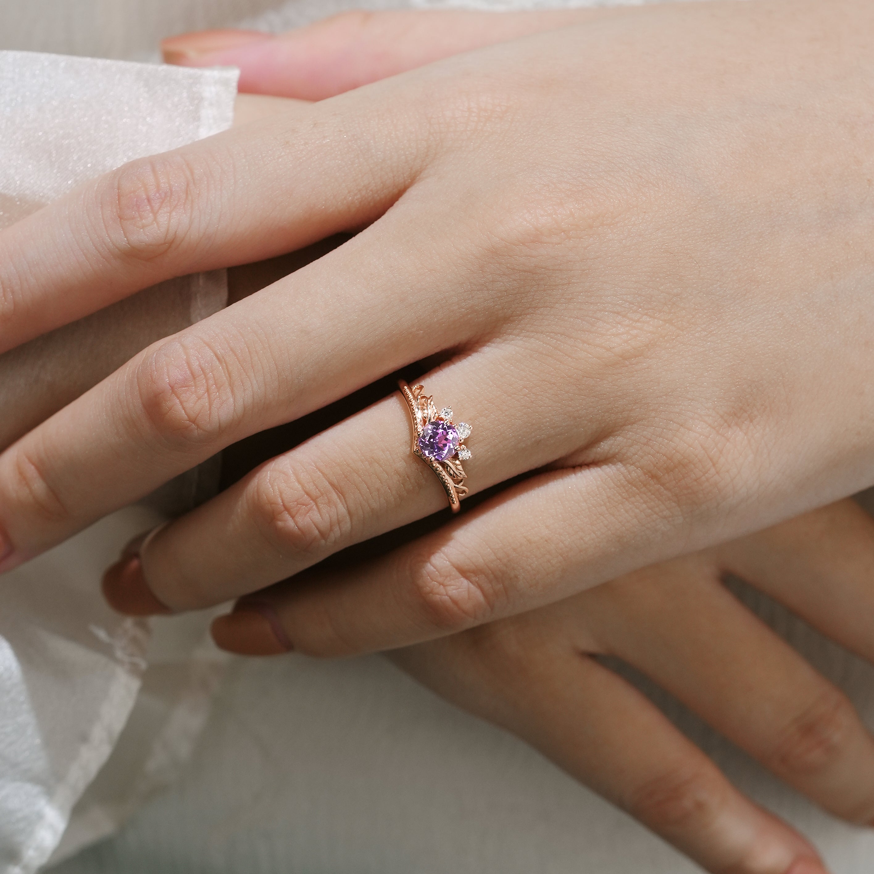 Woman's hand wearing a purple sapphire leaf engagement ring by Lahela Jewelry