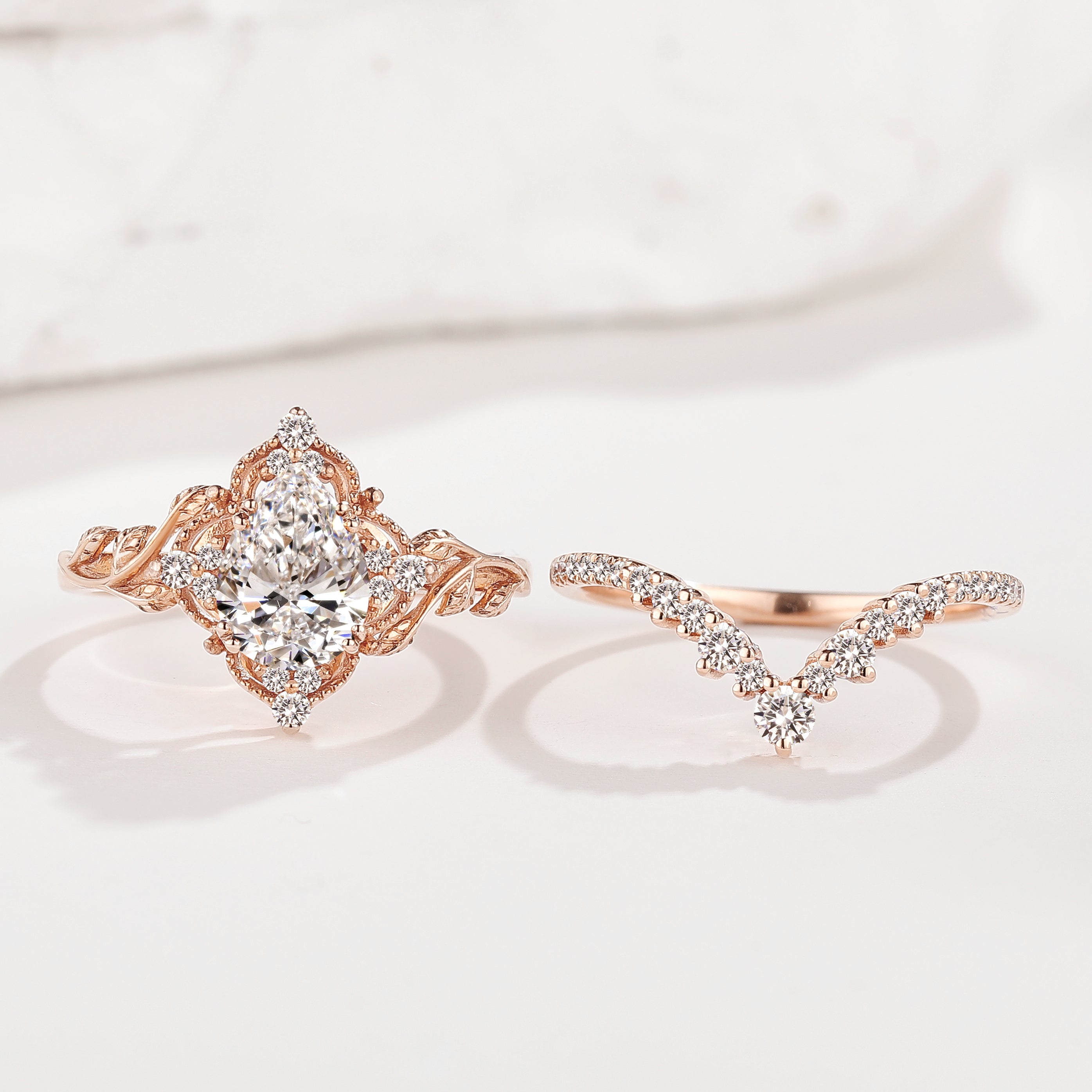 Rose gold pear cut diamond engagement ring set with leaf design and matching wedding band