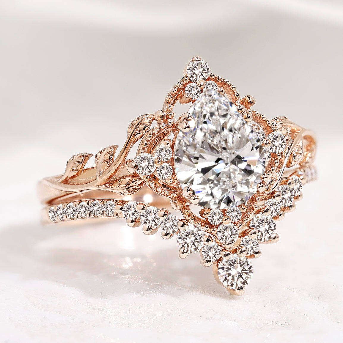 Rose gold pear cut lab diamond leaf engagement ring set with halo