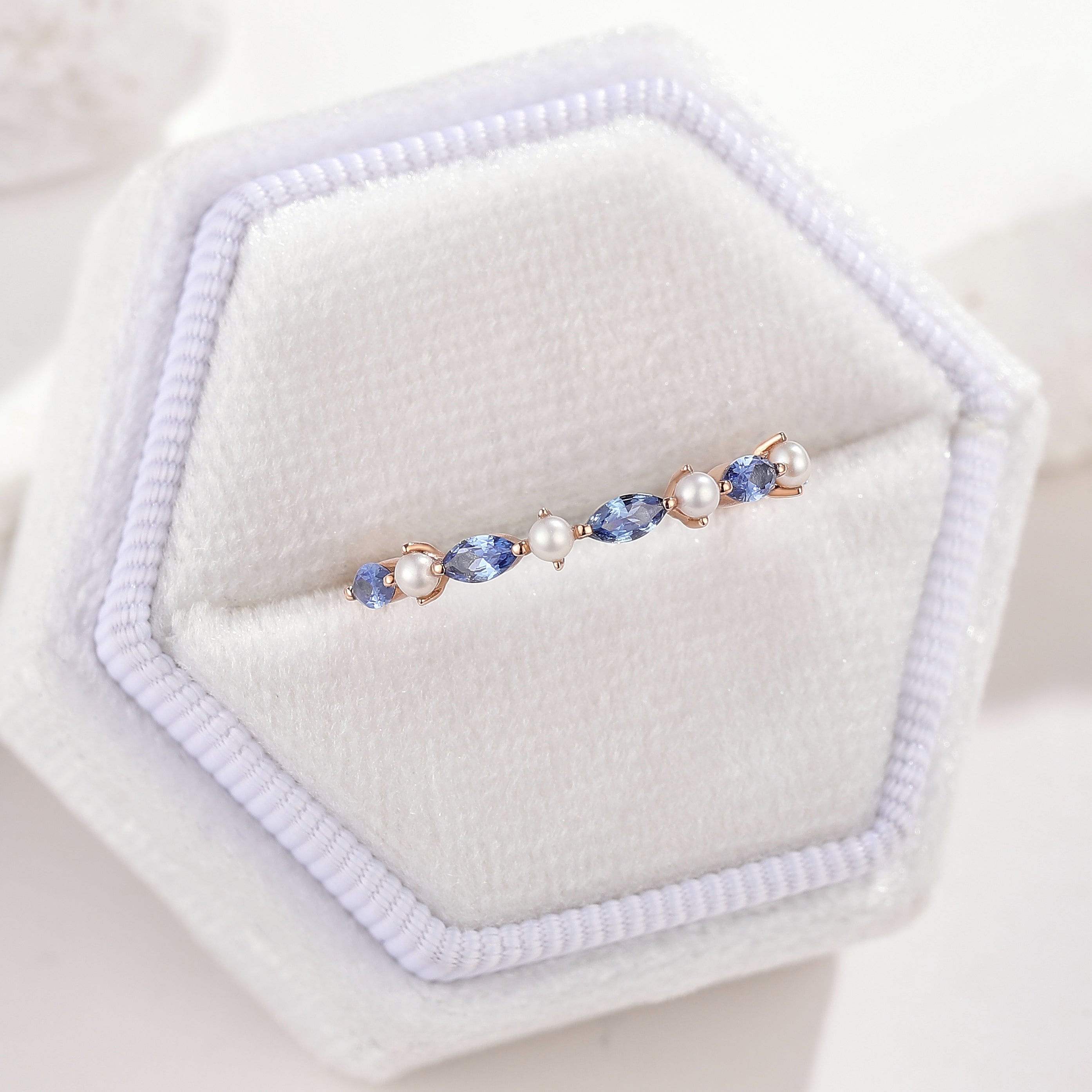 Marquise sapphire and pearl wedding band in a white jewelry box