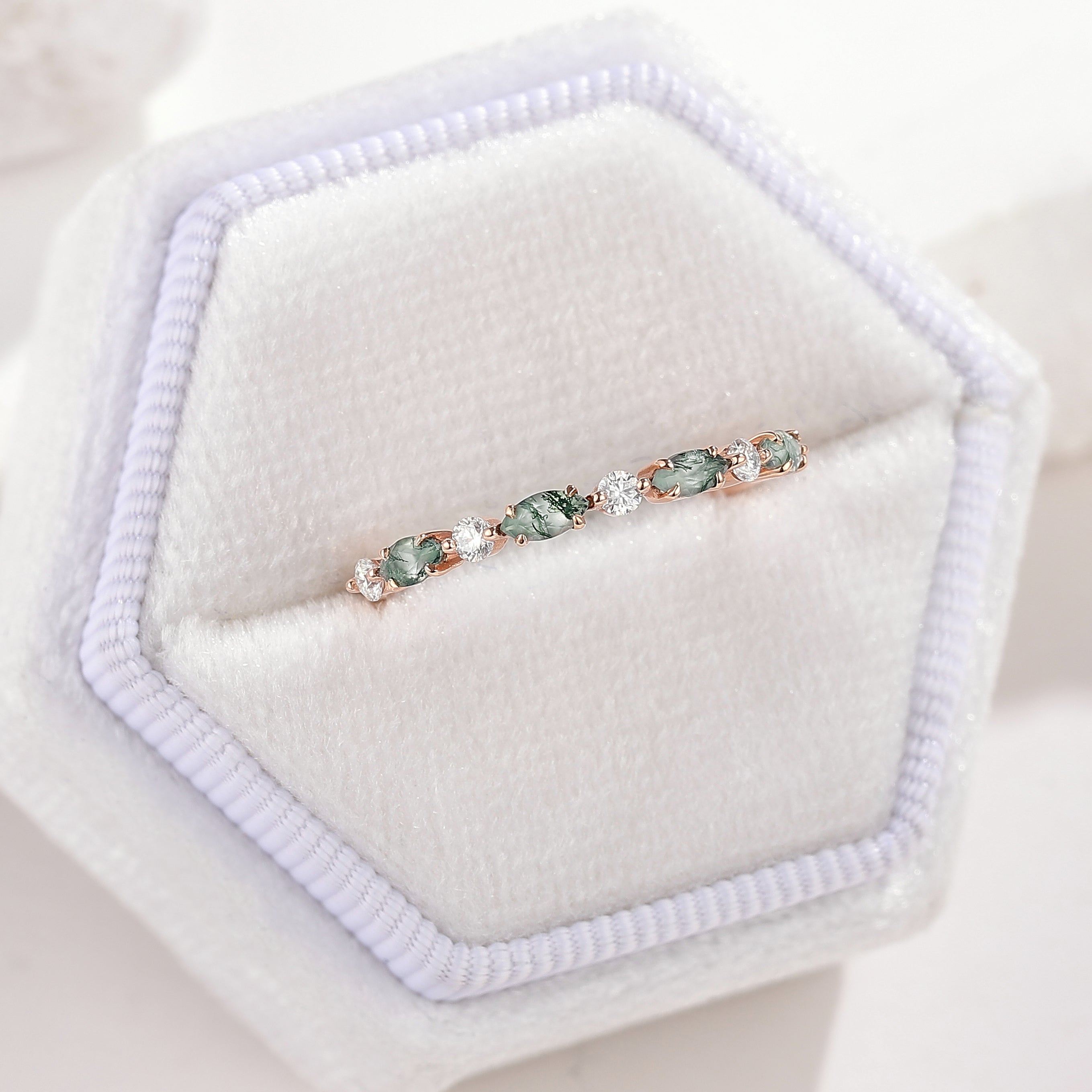 Rose gold moss agate and moissanite wedding band in a white box