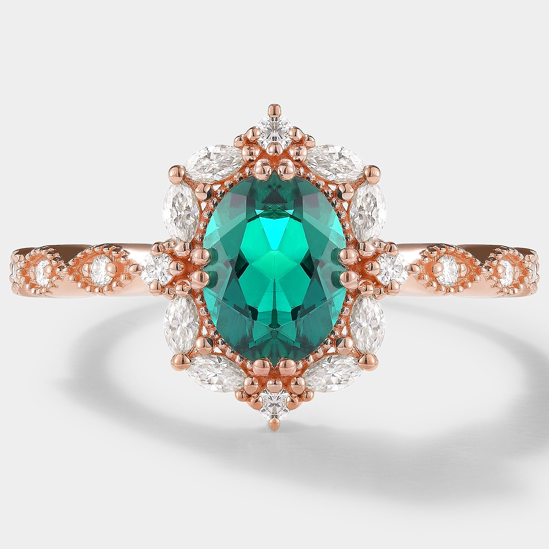 Rose gold emerald and moissanite engagement ring, oval cut