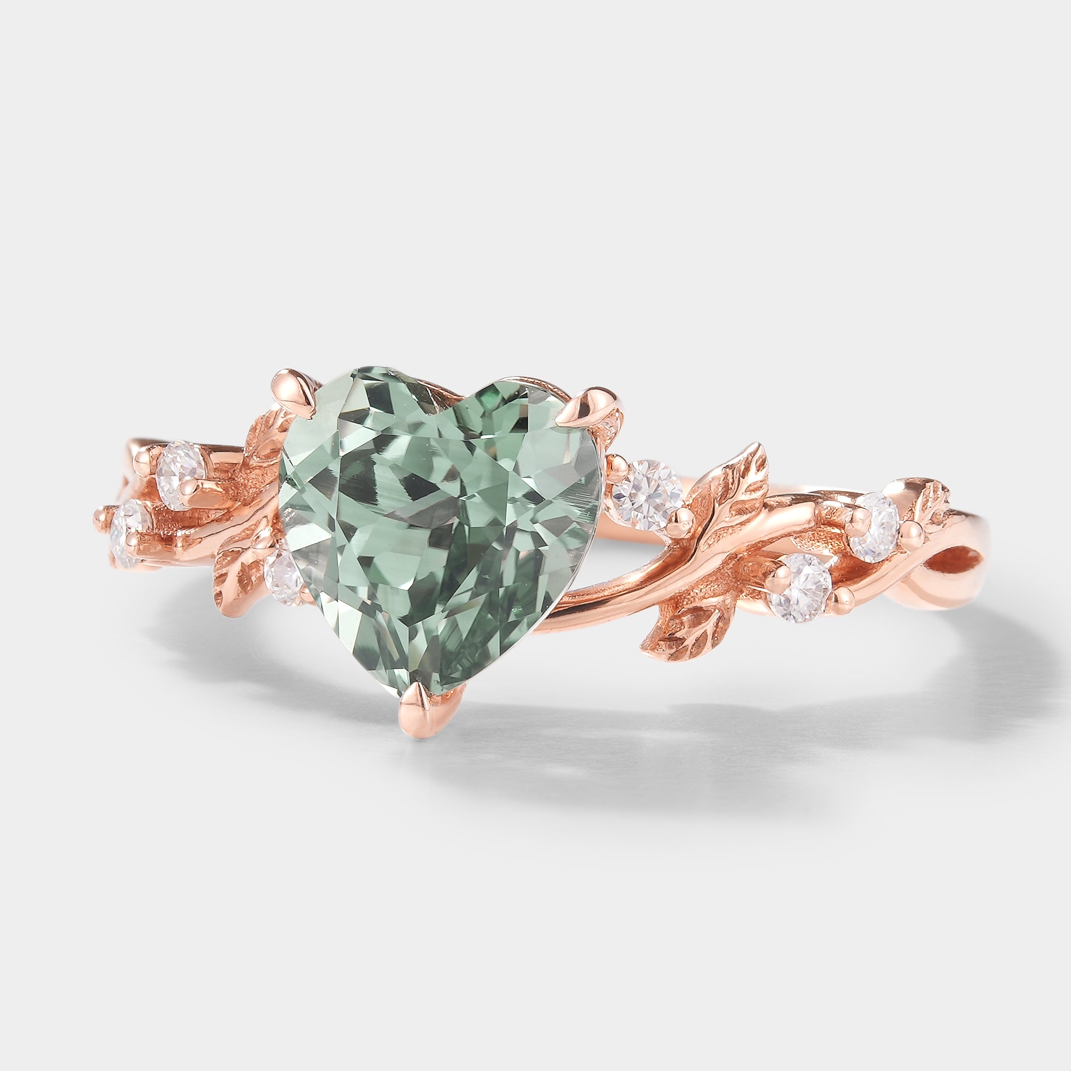 Heart-shaped green sapphire engagement ring with leaf accents