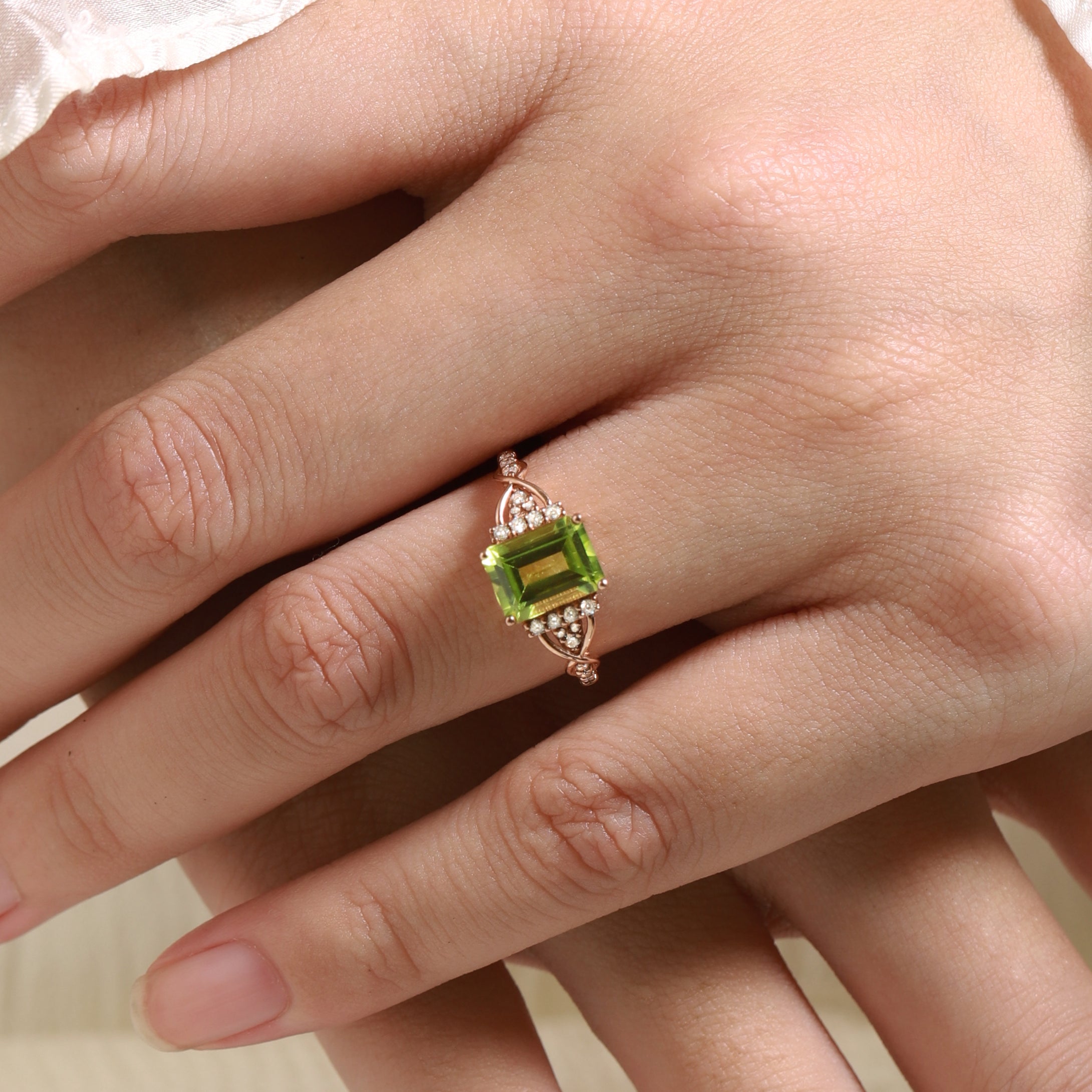 Elegant emerald cut peridot engagement ring in rose gold, adorned with moissanite accents. A vintage style bridal ring.