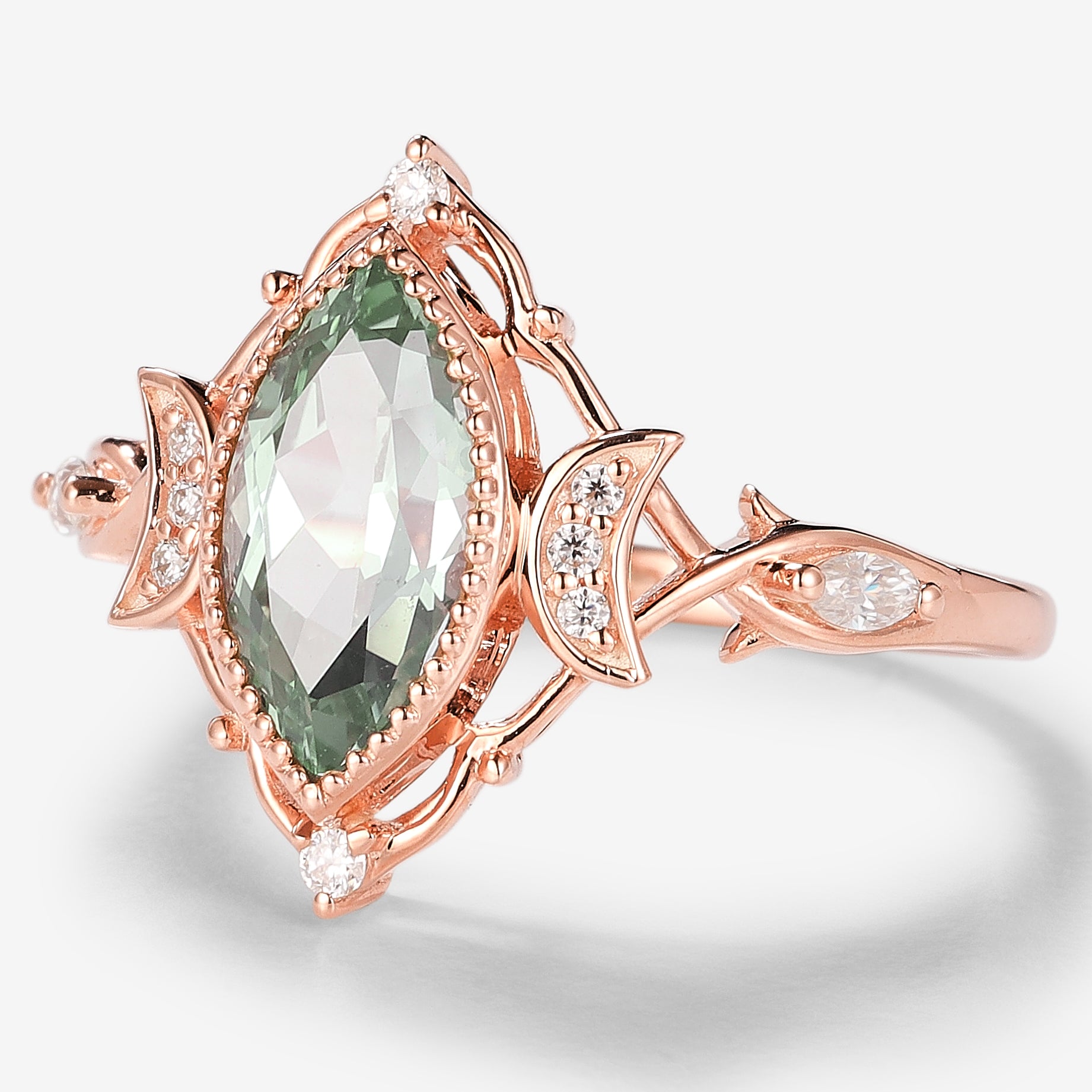 Rose gold marquise green sapphire engagement ring with moon motifs, moissanite accents, and vintage design