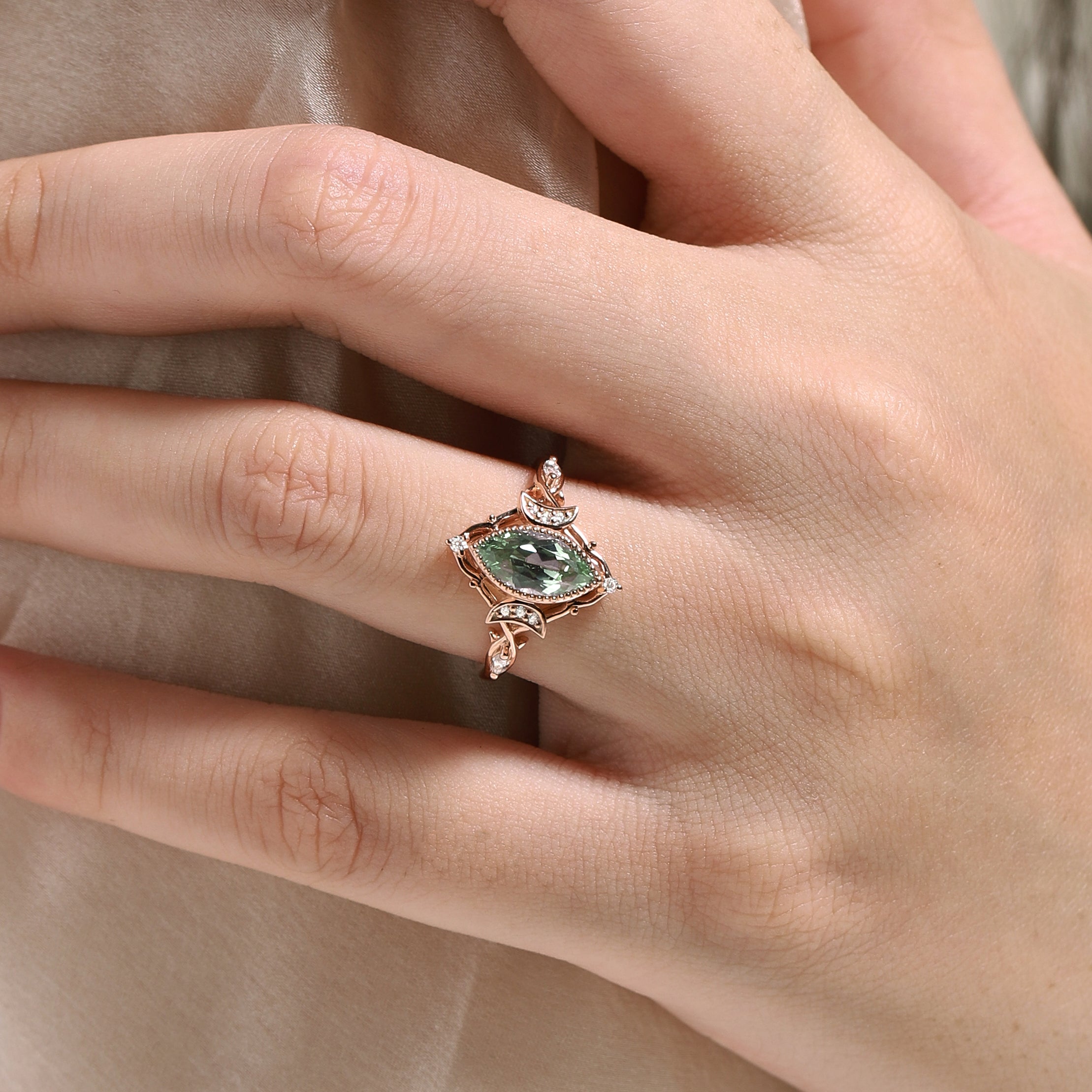 Marquise green sapphire engagement ring in rose gold, moon and moissanite accents, on hand, Lahela Jewelry