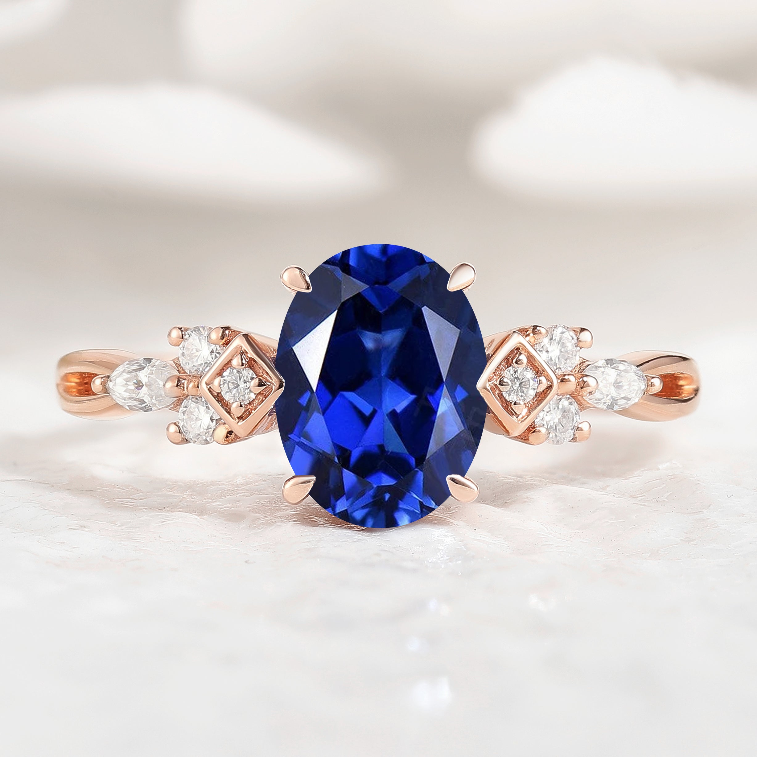 Oval cut royal blue sapphire engagement ring in rose gold with moissanite accents