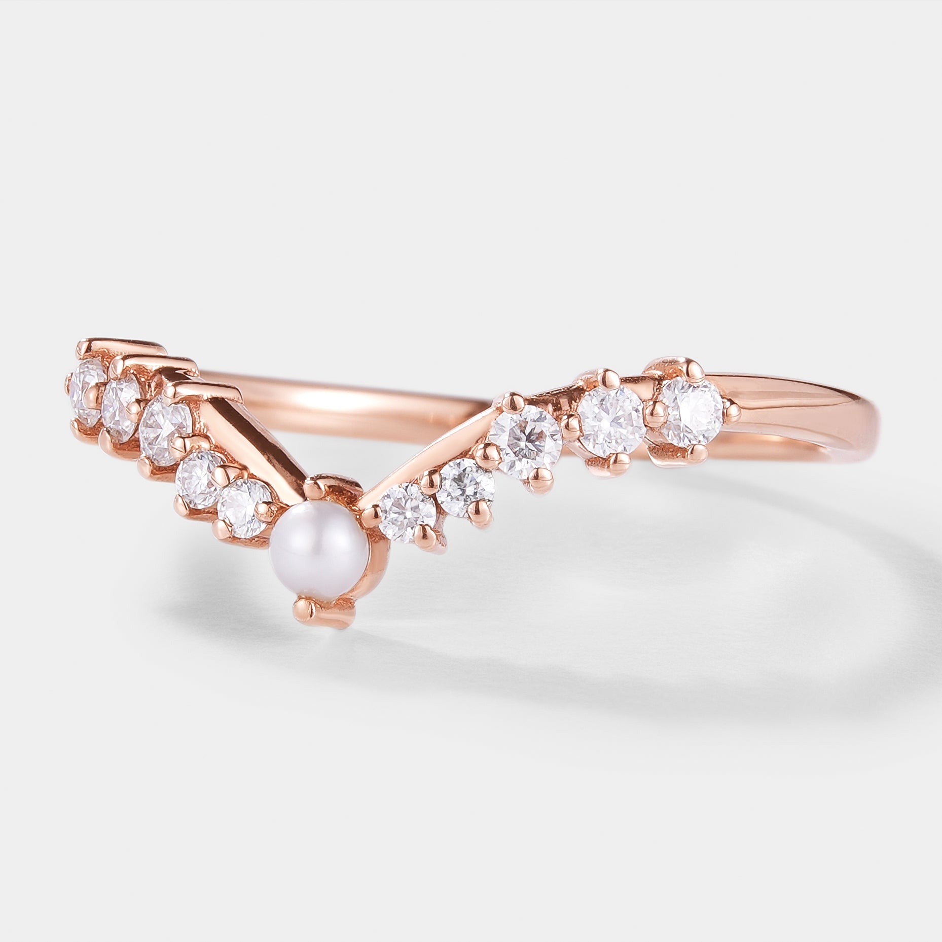 Rose gold curved wedding band with moissanite and pearl accents, bridal ring set