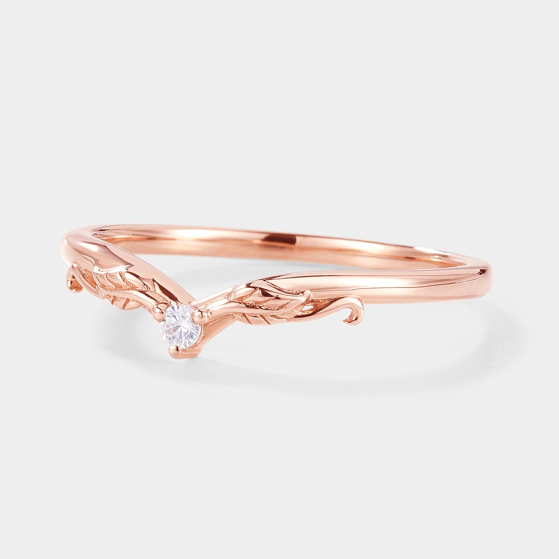 Rose gold V-shaped moissanite wedding band with leaf detailing.