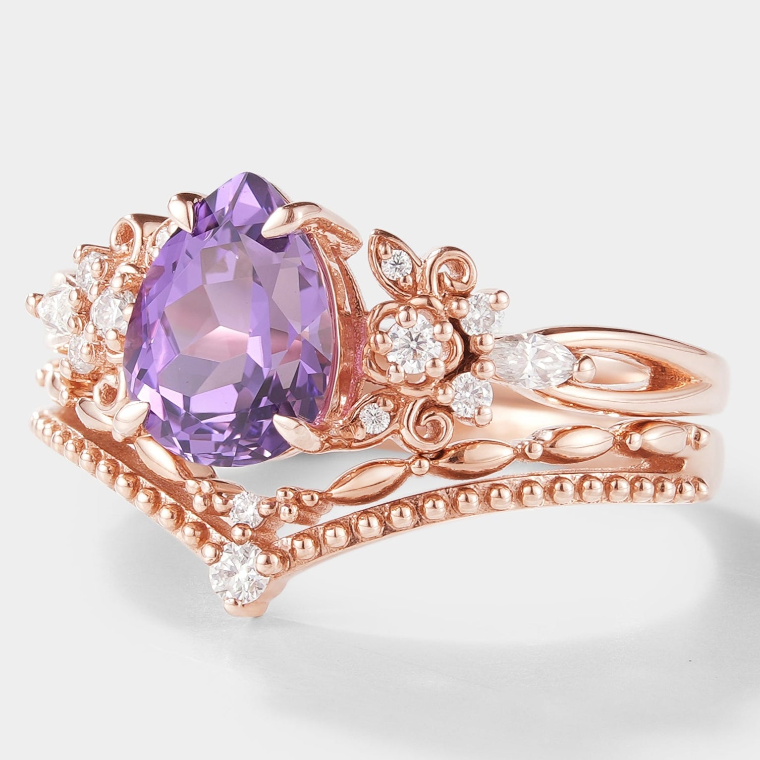 Nature-inspired pear-cut purple sapphire engagement ring set with floral details