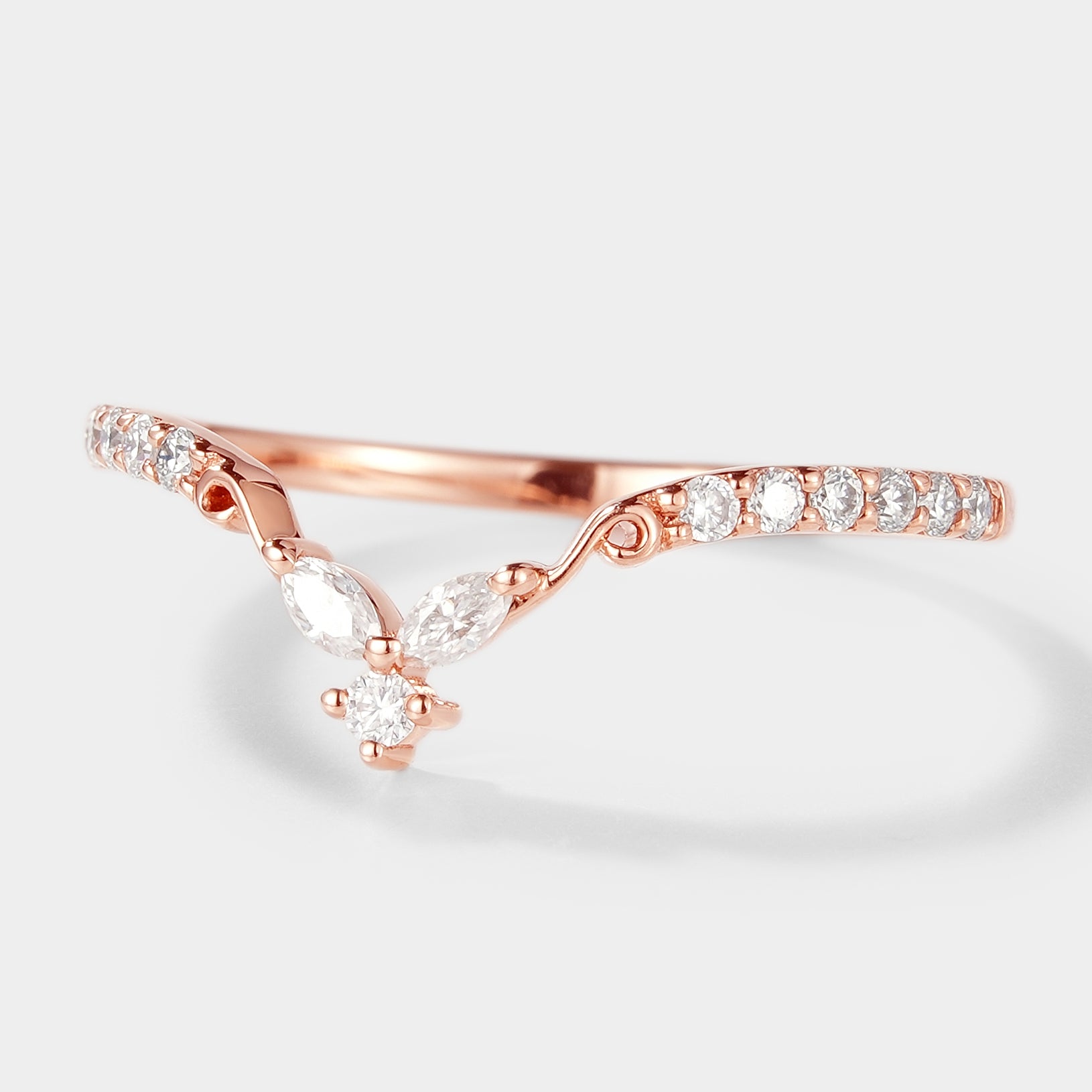 Rose gold moissanite wedding band with unique V-shaped design.