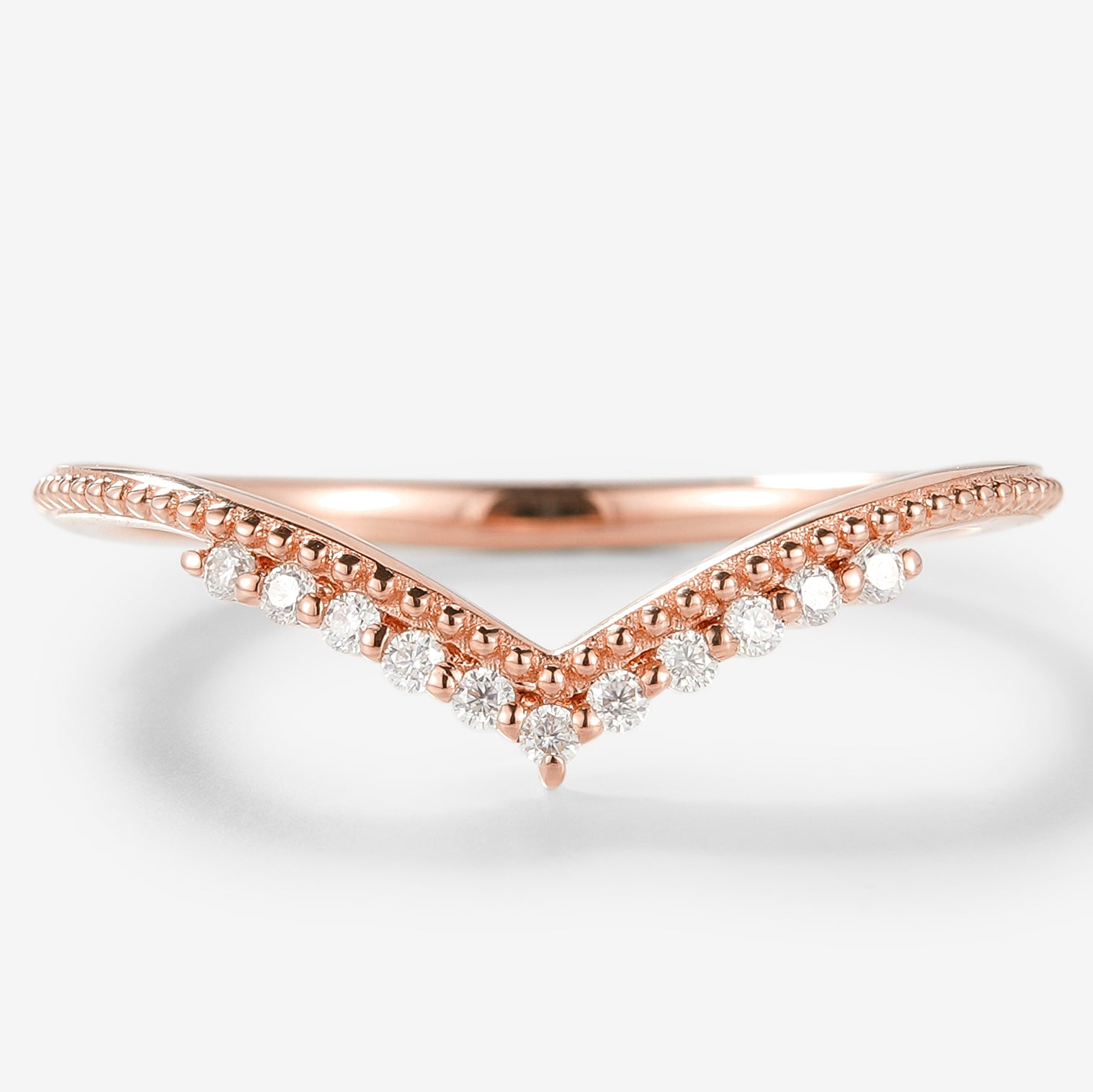 Rose gold moissanite V-shaped wedding band with milgrain detailing.