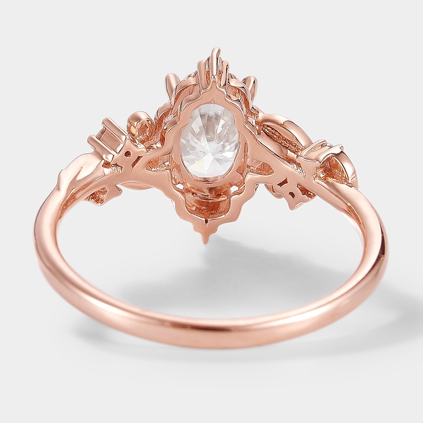 Rose gold Aurelia engagement ring, oval moissanite center stone with leaf design.