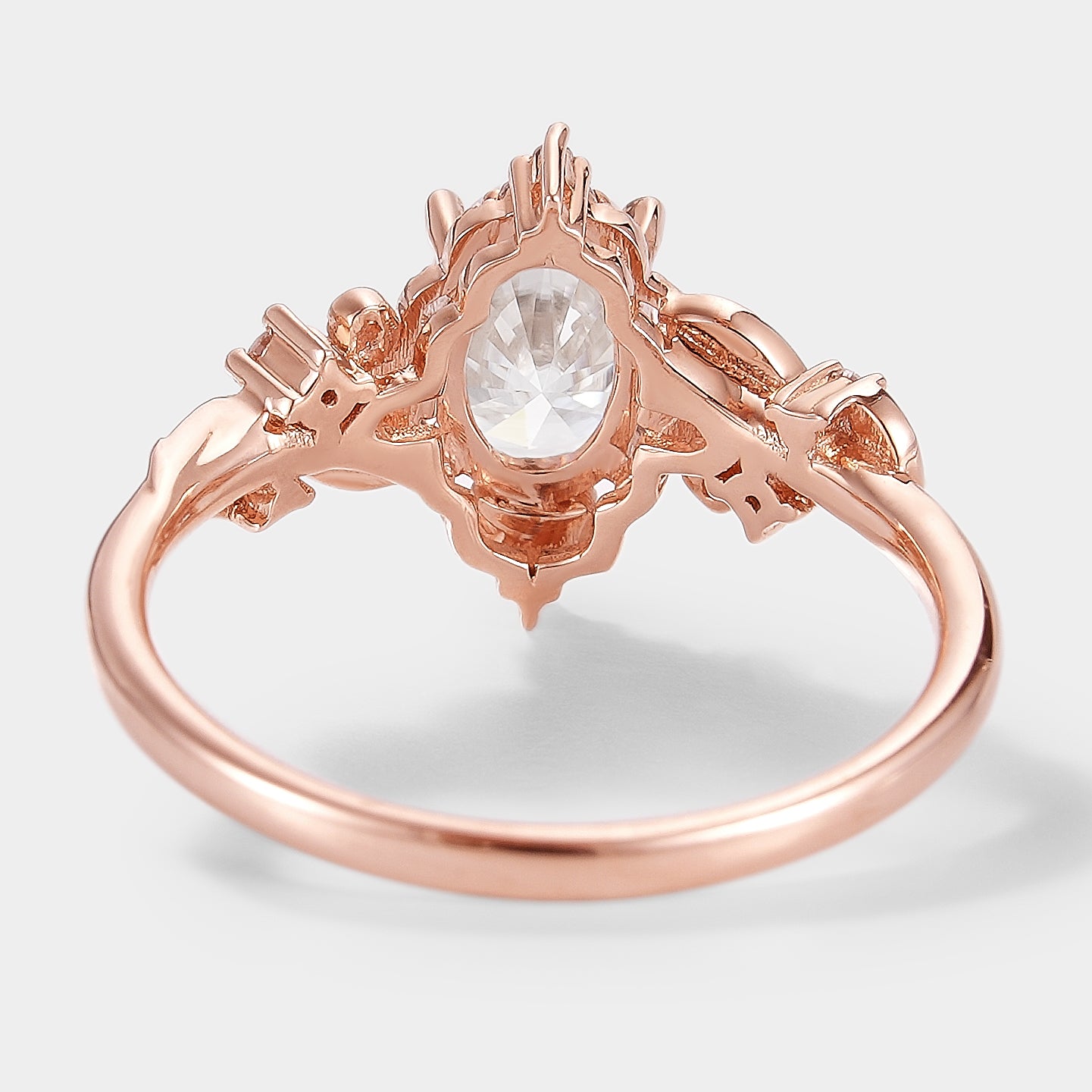 Rose gold Aurelia engagement ring, oval moissanite center stone with leaf design.