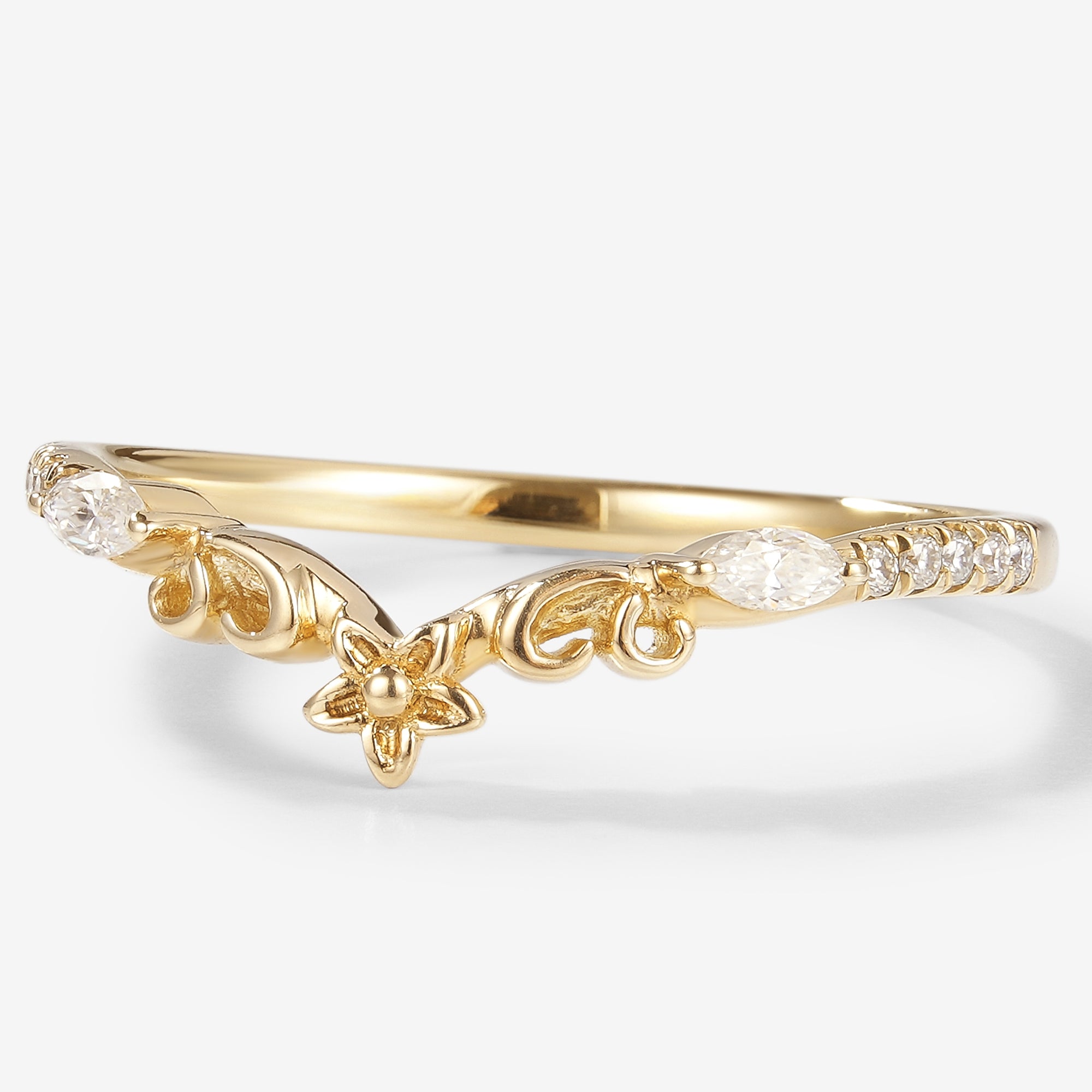 Yellow gold moissanite floral wedding band. Features a delicate flower design and sparkling moissanite stones.