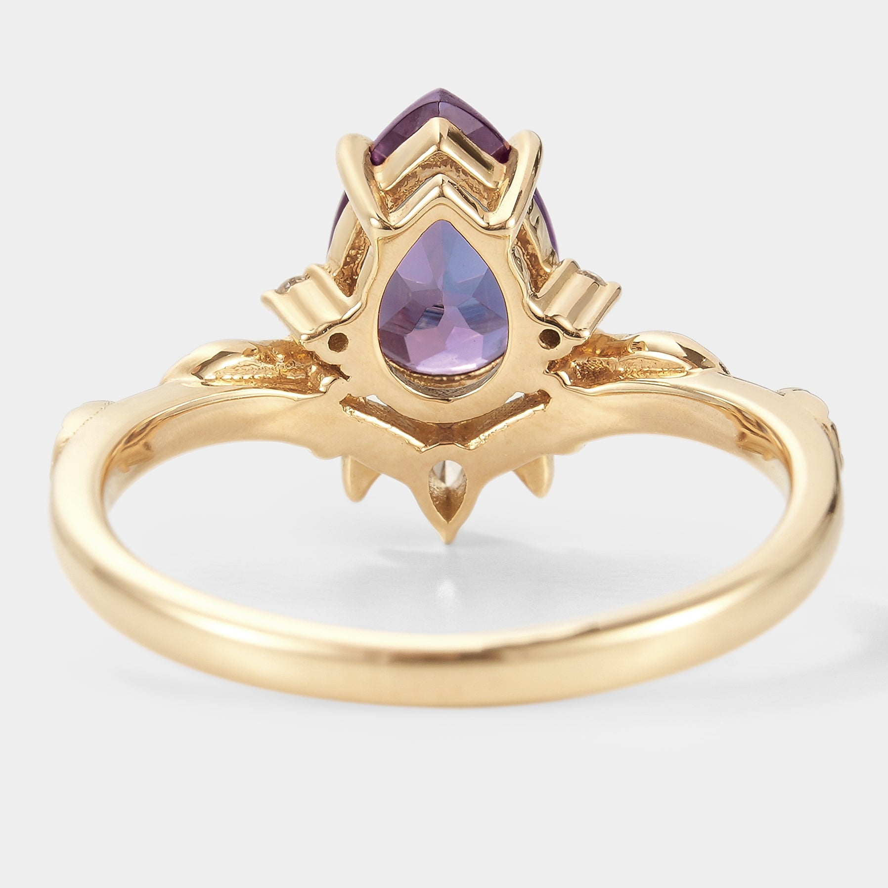 Pear-cut alexandrite engagement ring in yellow gold with leaf design