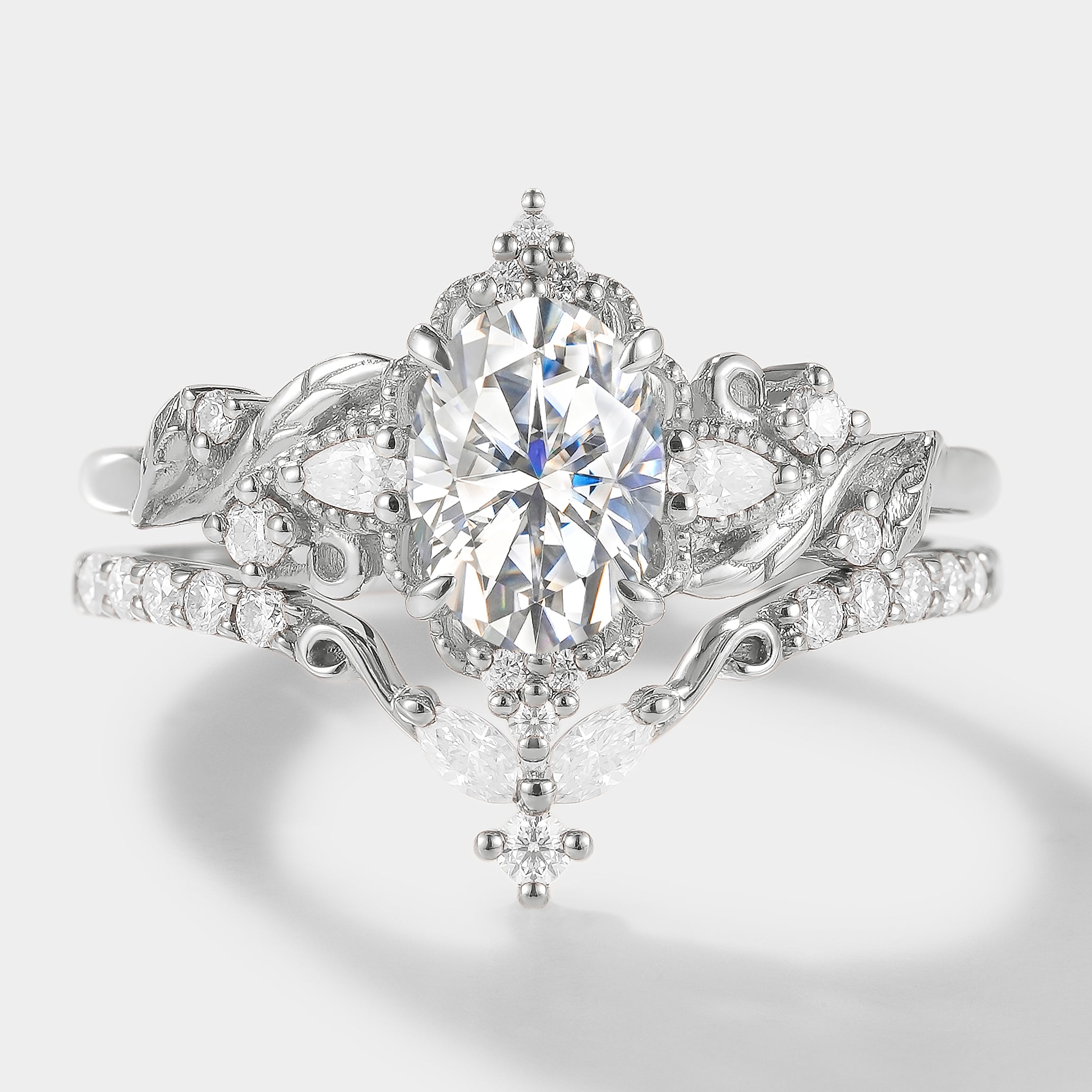 Elongated oval cut moissanite ring set in white gold. Leaf design engagement ring & wedding band. Bridal ring set.