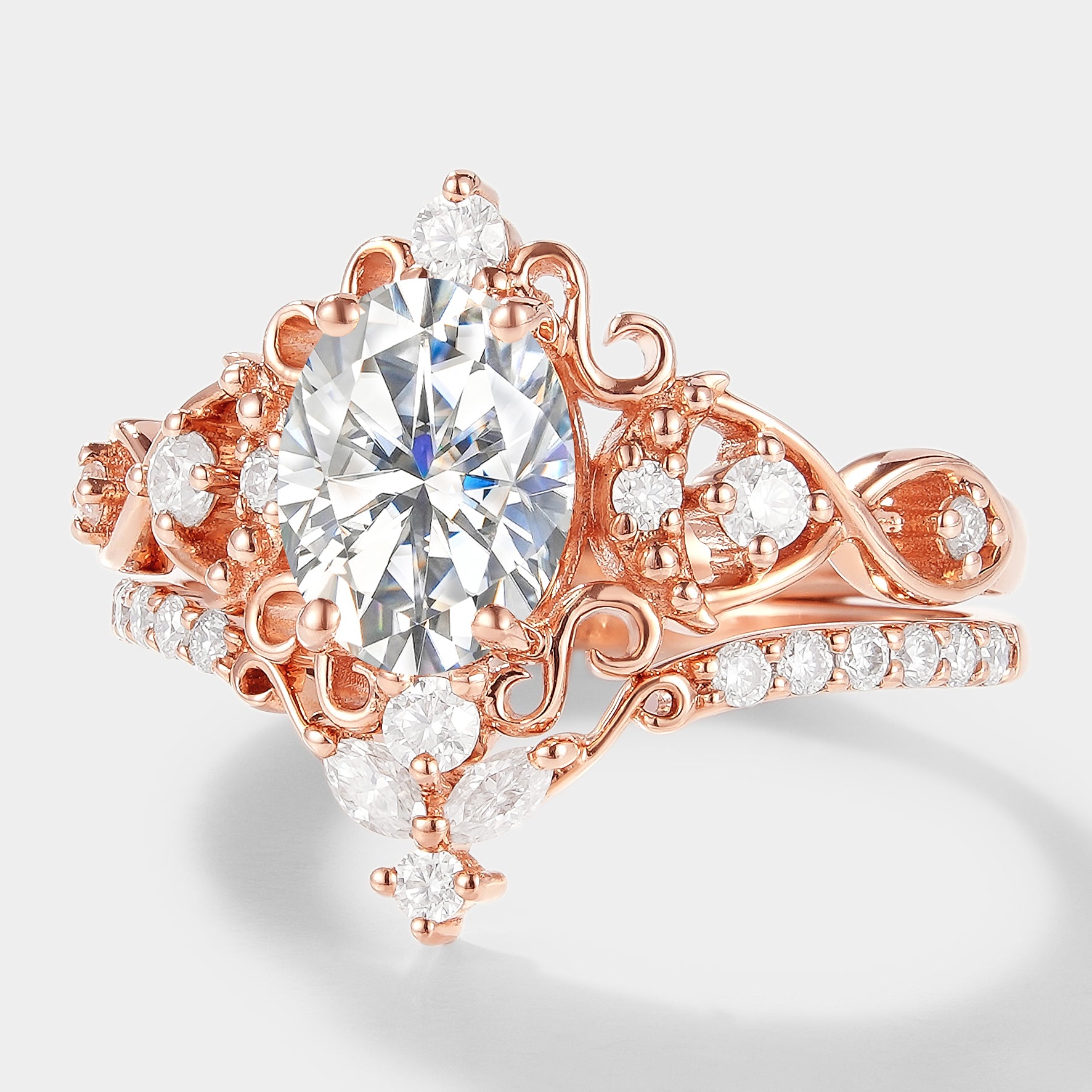 Vintage rose gold moissanite engagement ring set with oval cut center stone and moissanite wedding band.