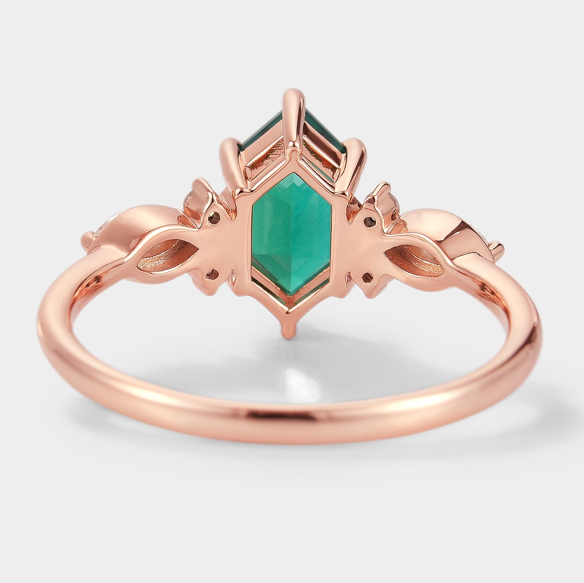 Rose gold engagement ring with hexagon-cut lab-grown emerald, vintage design, moissanite accents. Perfect for proposals.