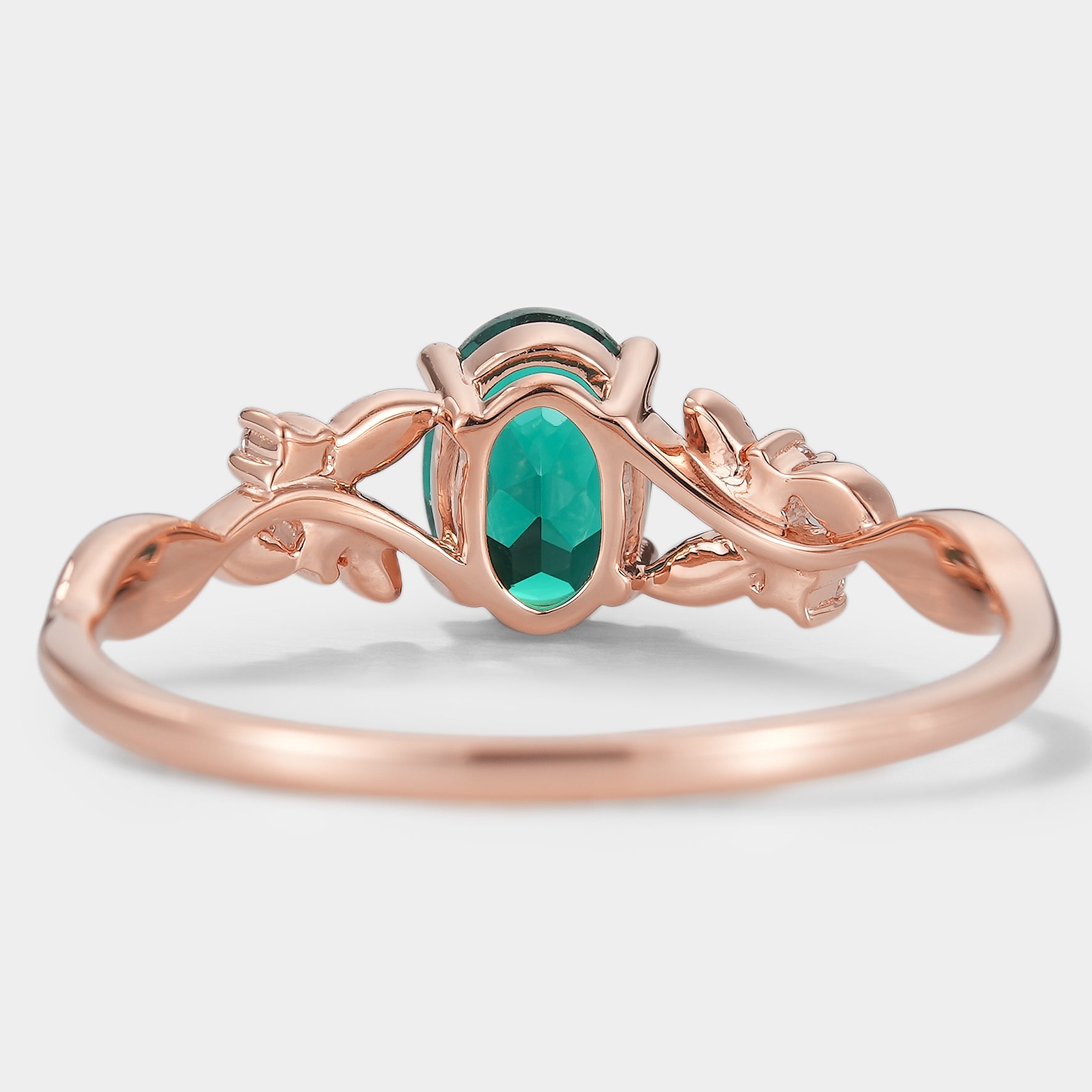 Oval lab grown emerald engagement ring with leaf design in rose gold. Wedding ring.