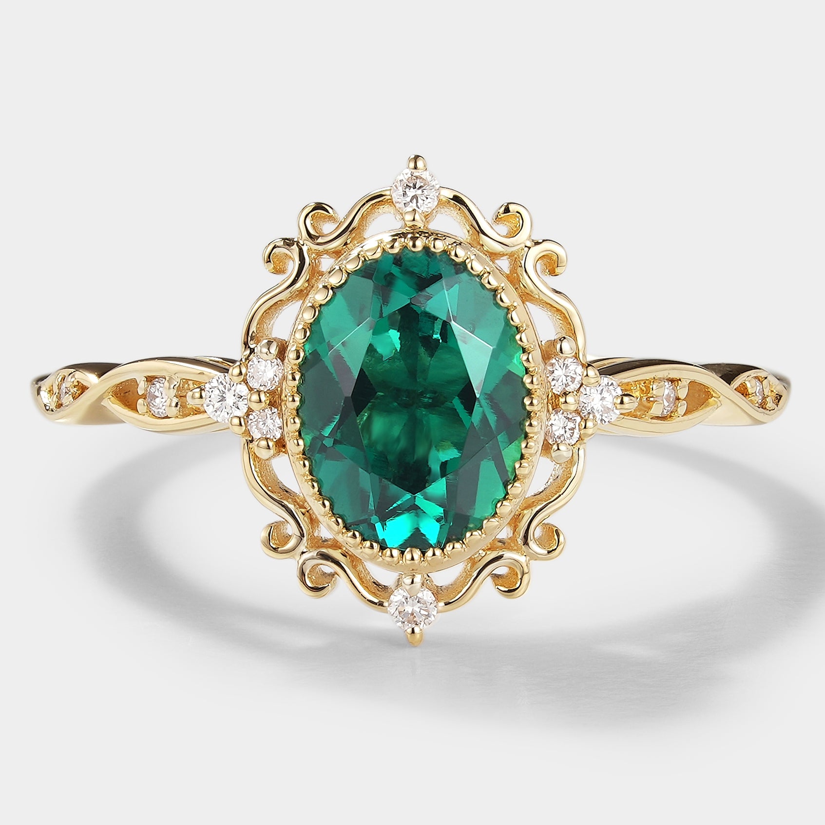 Vintage lab-grown emerald engagement ring with moissanite accents in a yellow gold band.