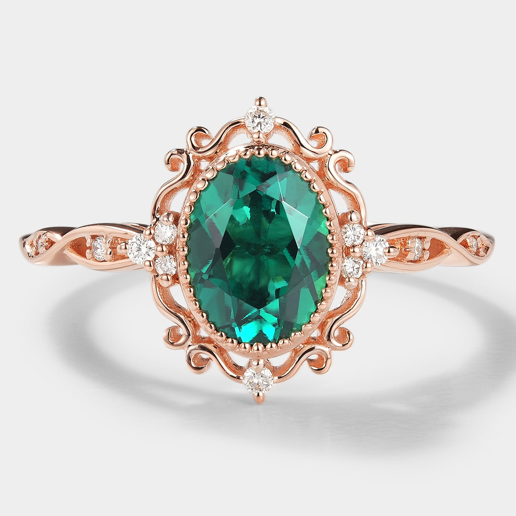Vintage lab grown emerald engagement ring with moissanite accents in rose gold.