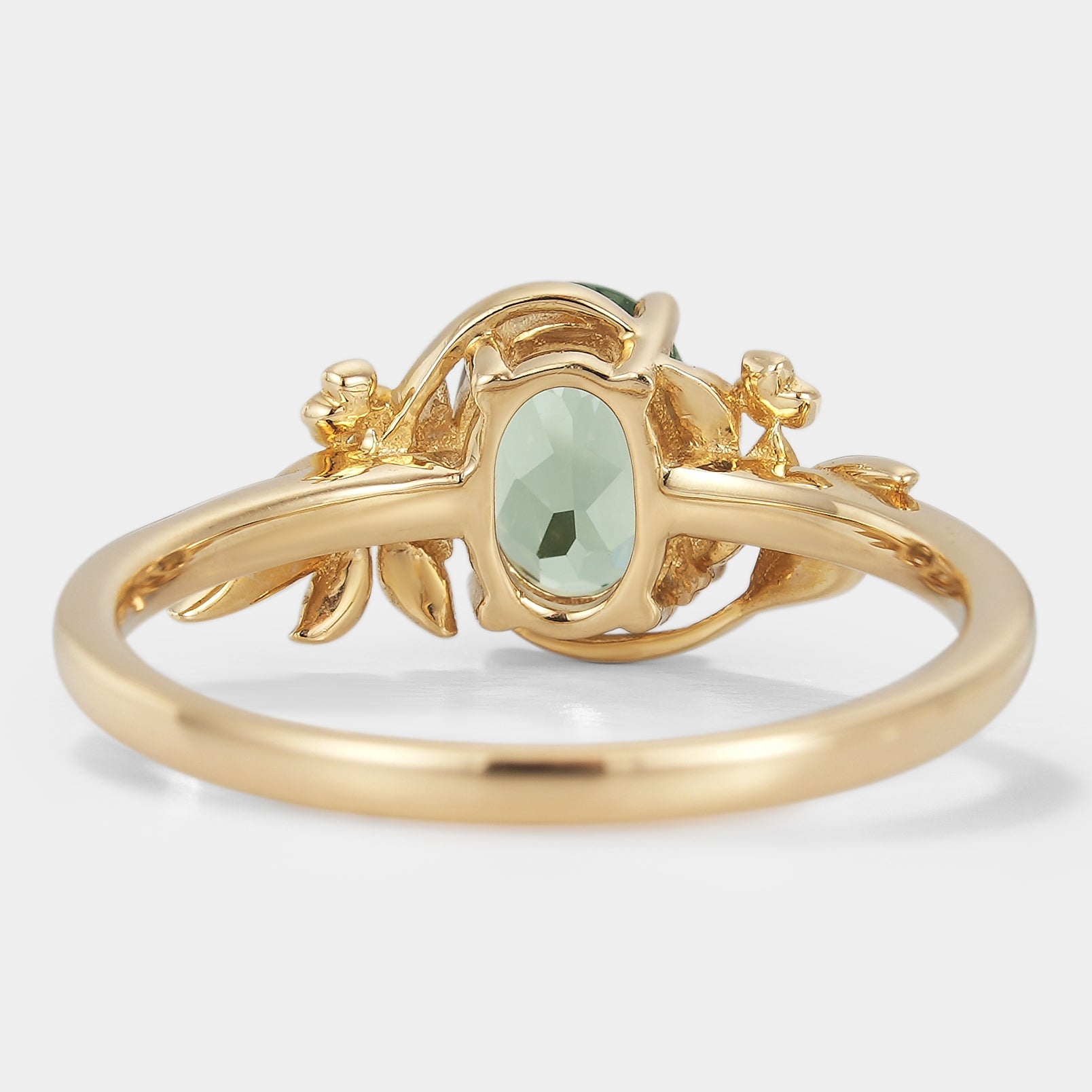 Oval lab grown green sapphire engagement ring with leaf and flower accents in gold