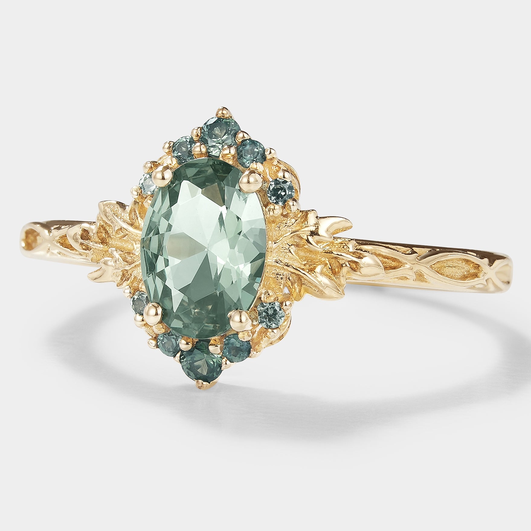 Oval green sapphire engagement ring with leaf pattern in gold, bridal jewelry