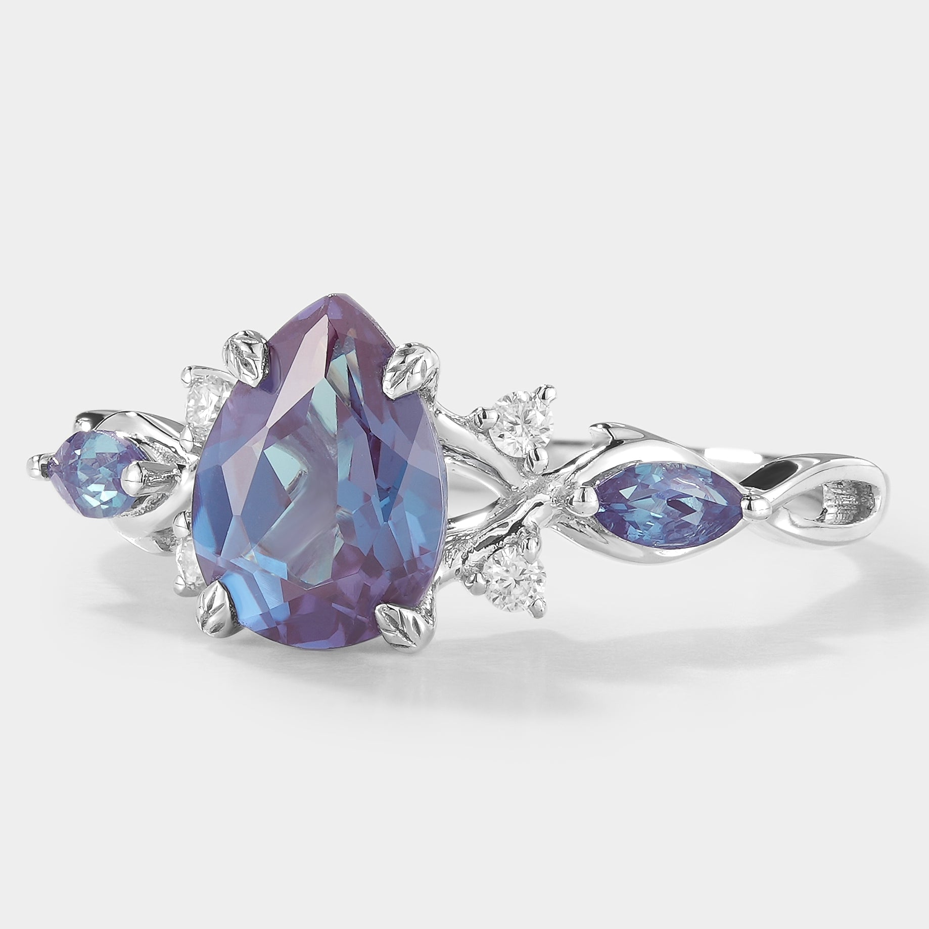 Classic pear-cut alexandrite engagement ring with moissanite accents in leaf design.
