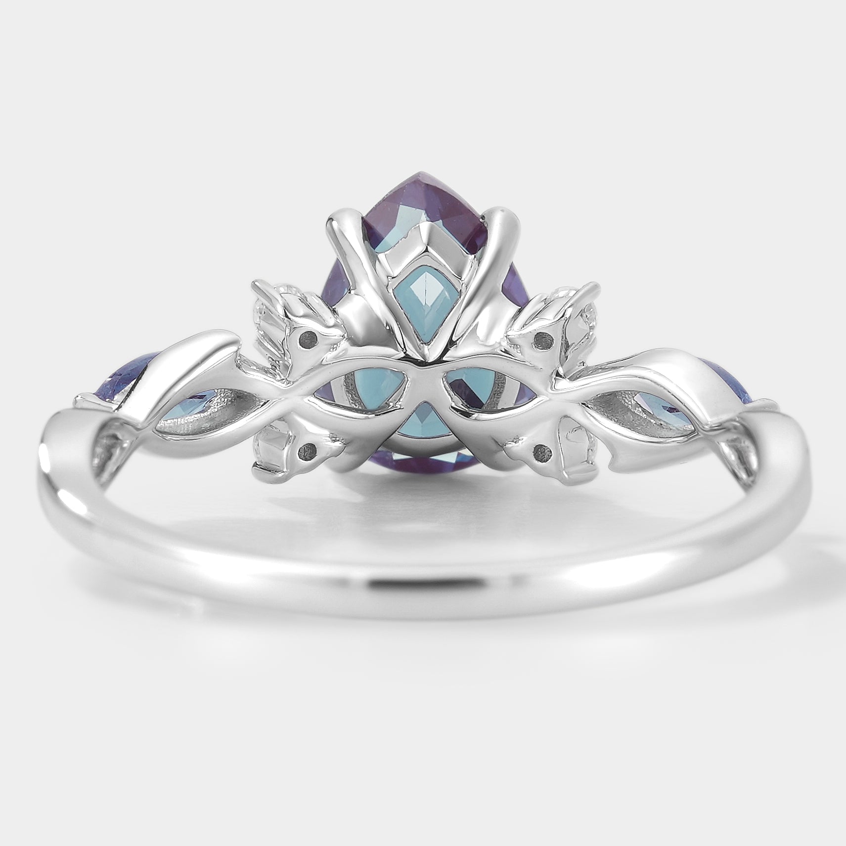 Elegant pear-cut alexandrite engagement ring with floral design, featuring moissanite accents. Lahela Jewelry.