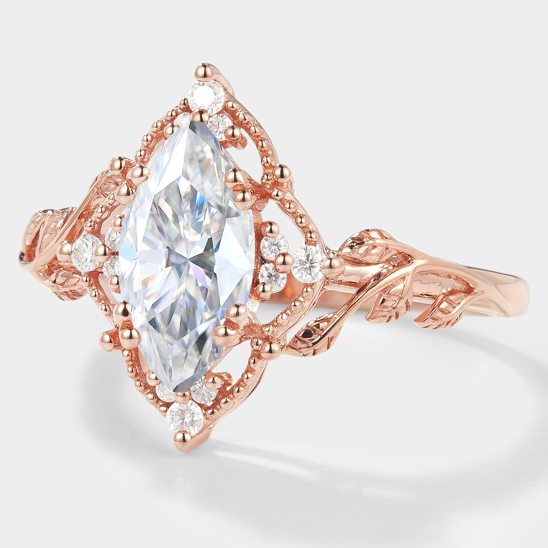 Nature-inspired marquise moissanite engagement ring with rose gold and leaf details