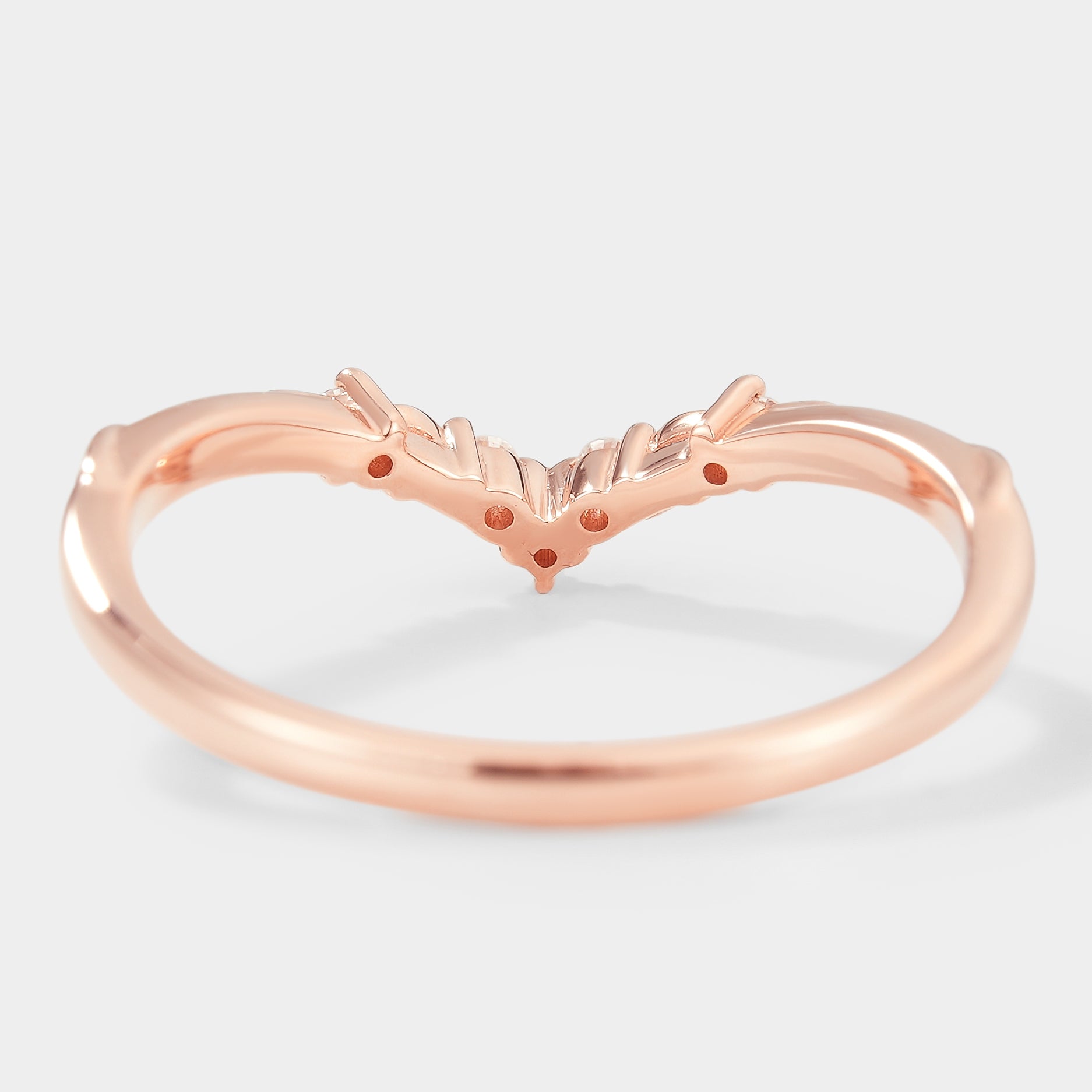 Rose gold V-shaped wedding band with leaf details and moissanite stones