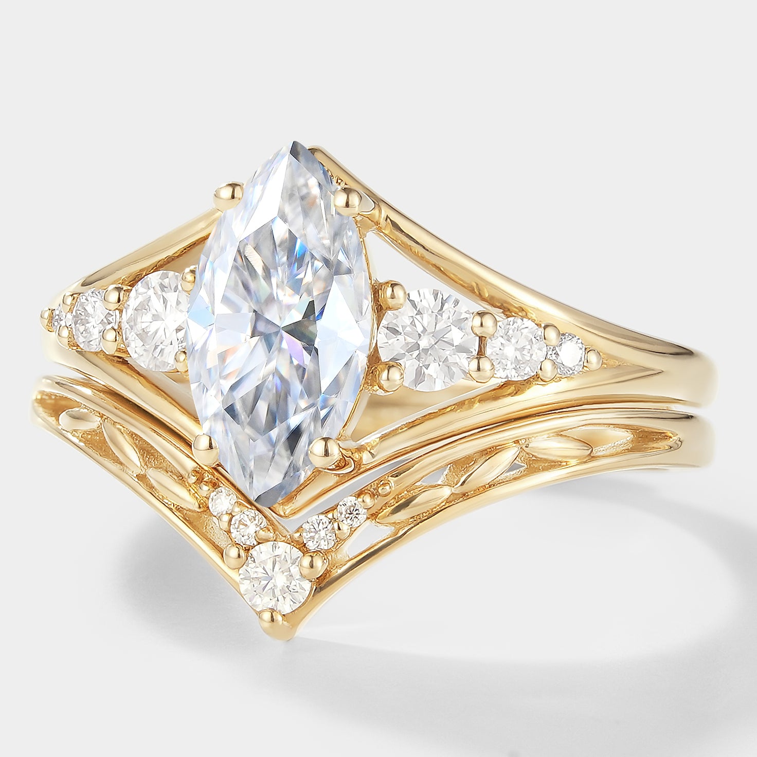 Marquise moissanite engagement ring bridal set, yellow gold. Chevron wedding band, elegant design.
