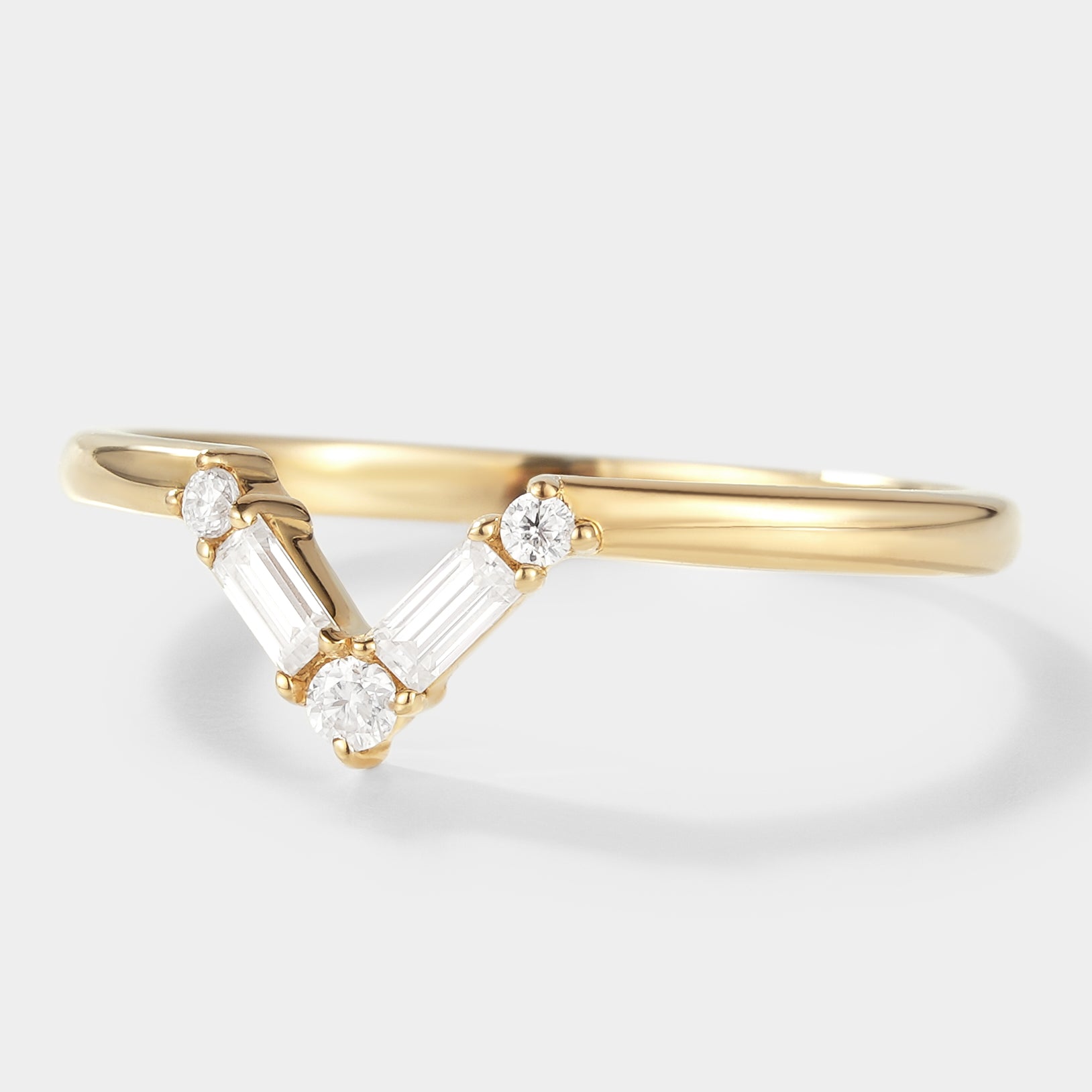 14K yellow gold chevron wedding band featuring round and baguette moissanite stones. Perfect for bridal set.
