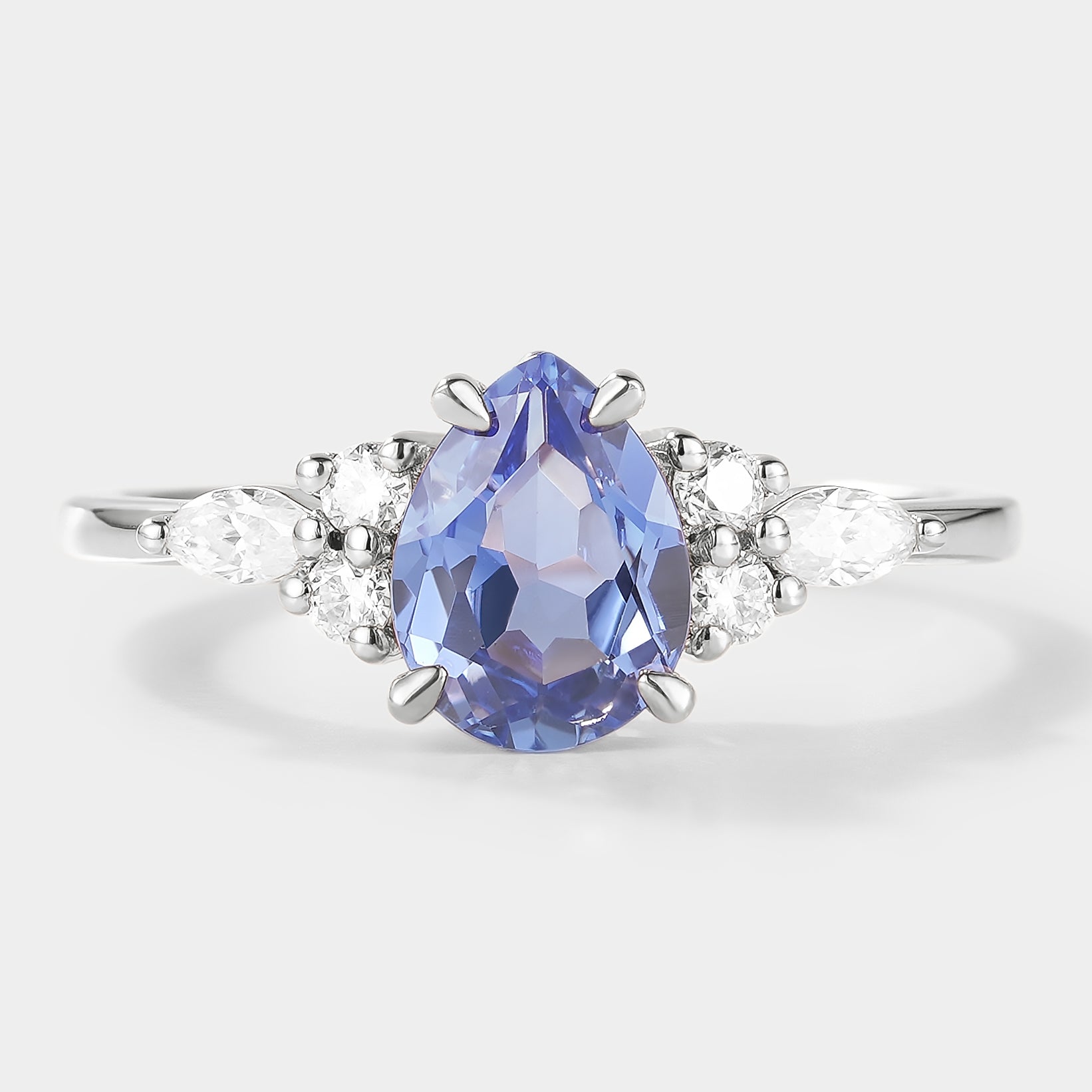 Elegant pear-cut lab grown cornflower sapphire engagement ring with moissanite accents, set in a white gold band, bridal set.