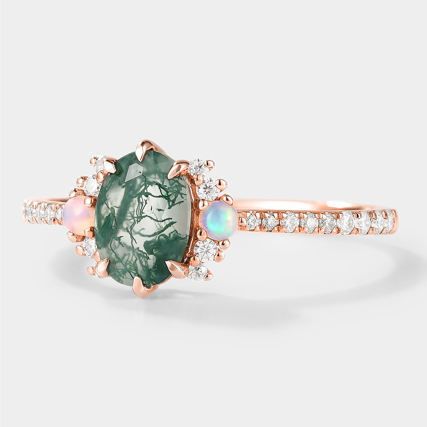 Rose gold oval moss agate engagement ring with opal and moissanite accents.
