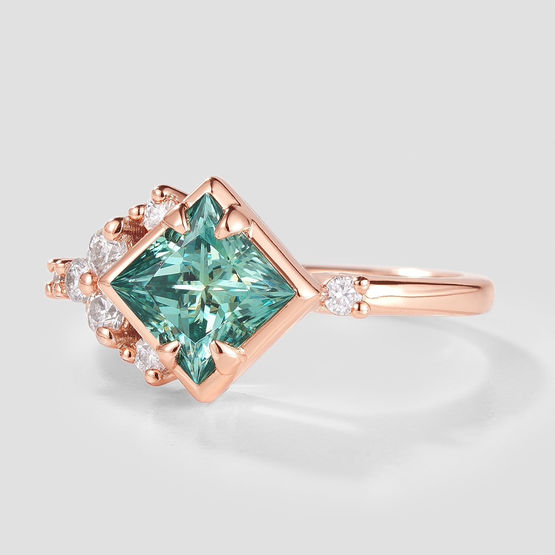 Rose gold engagement ring with green moissanite and diamond accents