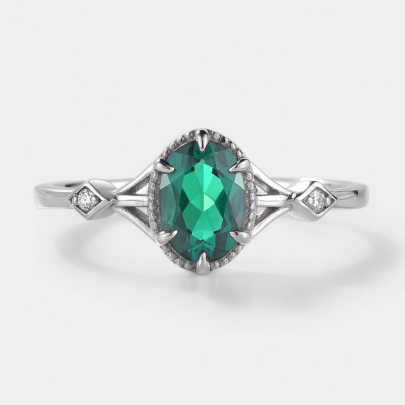 Oval emerald engagement ring with moissanite accents, silver band