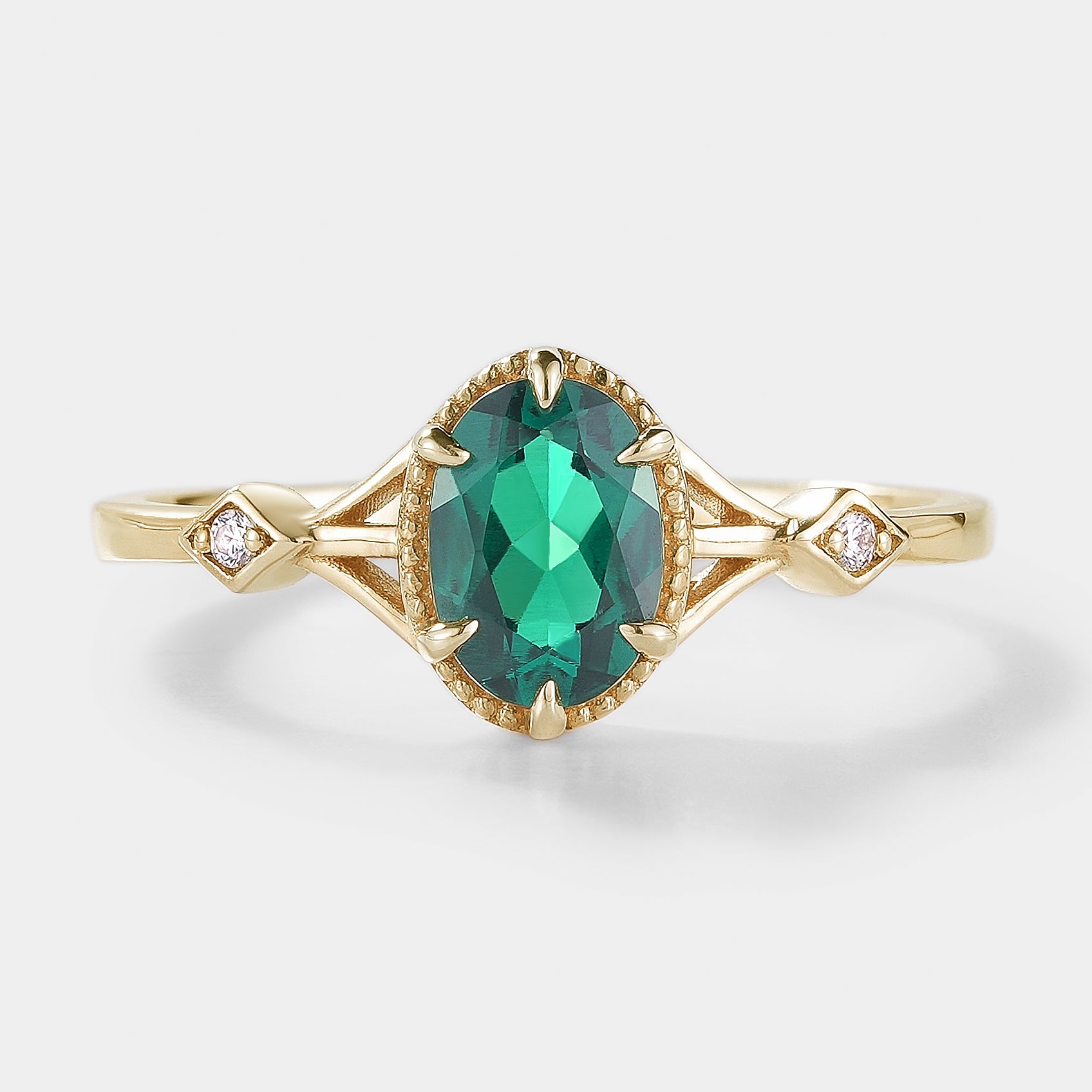 Oval emerald engagement ring in gold with moissanite accents