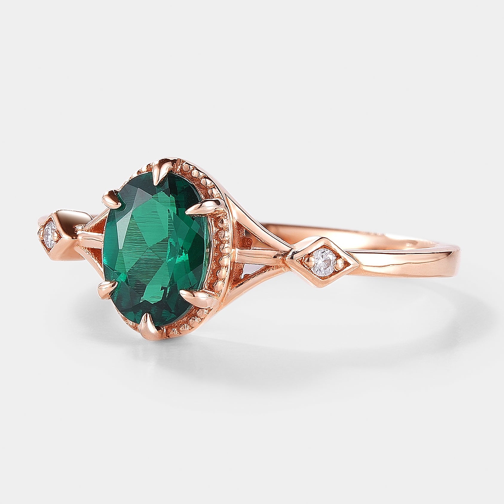 Oval emerald engagement ring with moissanite accents, rose gold