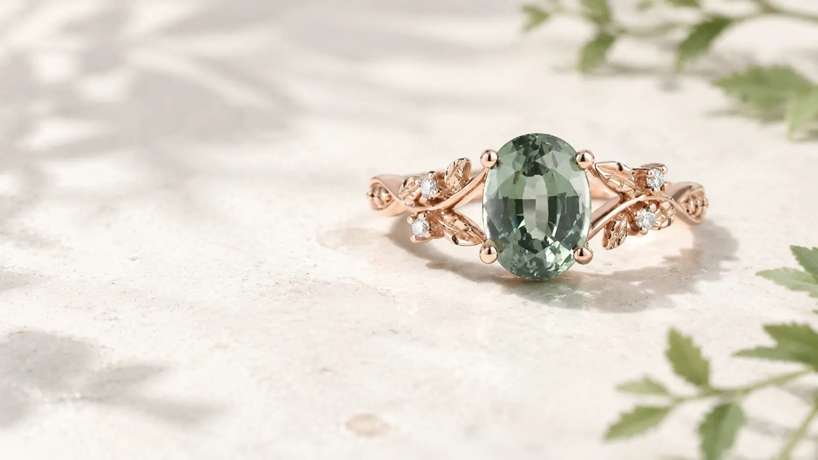 Oval green sapphire engagement ring with rose gold leaf and vine details
