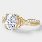 Oval moissanite engagement ring with leaf and bark design in yellow gold. Vintage style bridal ring.