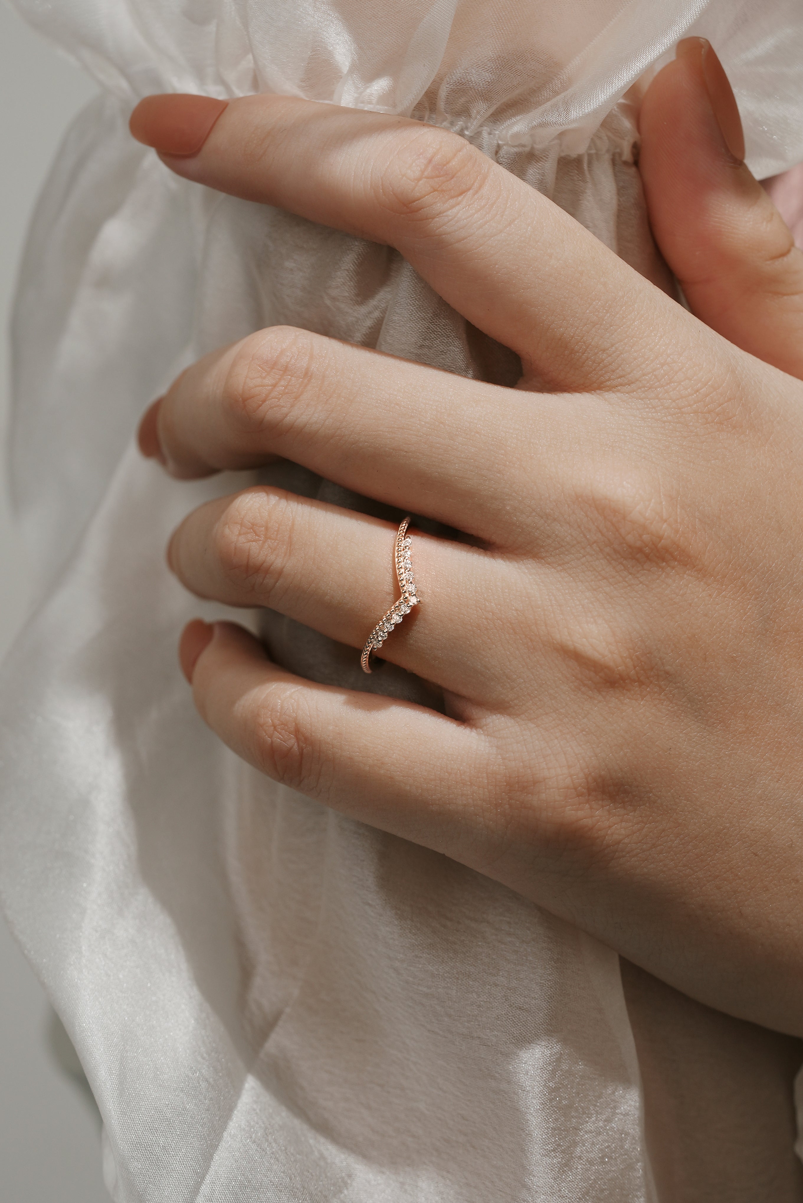 Rose gold moissanite wedding band on a hand, elegant bridal set ring.