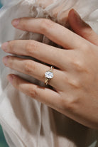 Oval moissanite engagement ring with leaf and bark design on a hand, Lahela Jewelry.