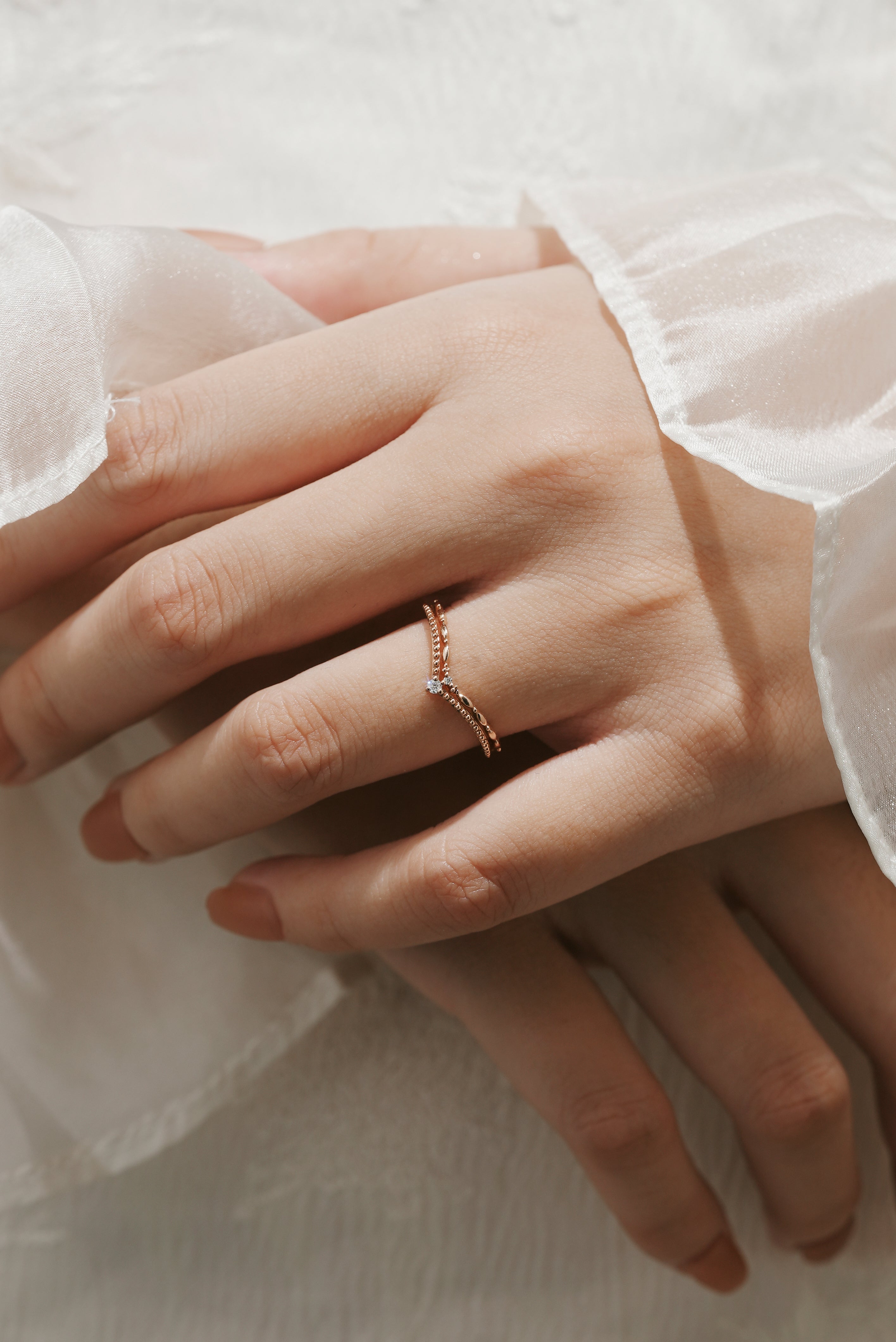 Rose gold V-shaped moissanite wedding band on a woman's hand