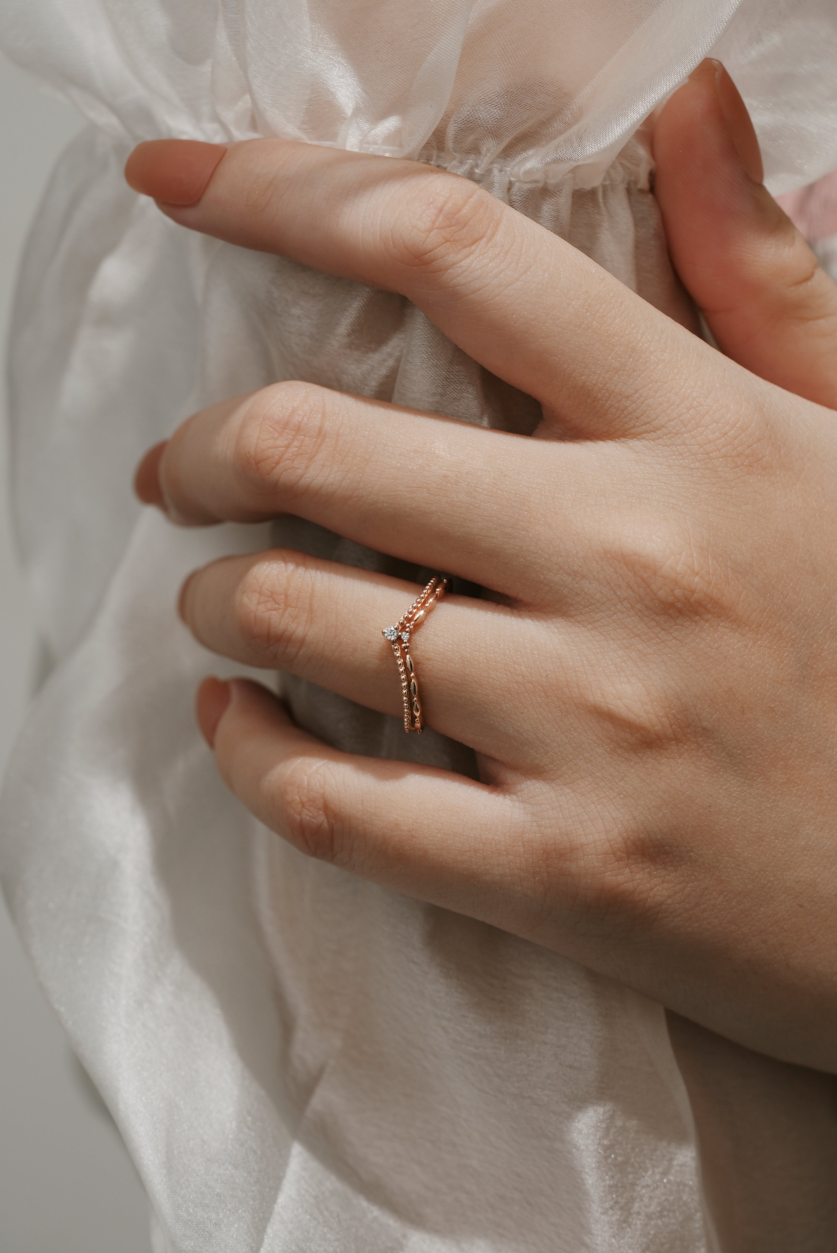 Elegant moissanite V-shaped wedding band on a woman's hand.