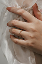 Elegant moissanite V-shaped wedding band on a woman's hand.